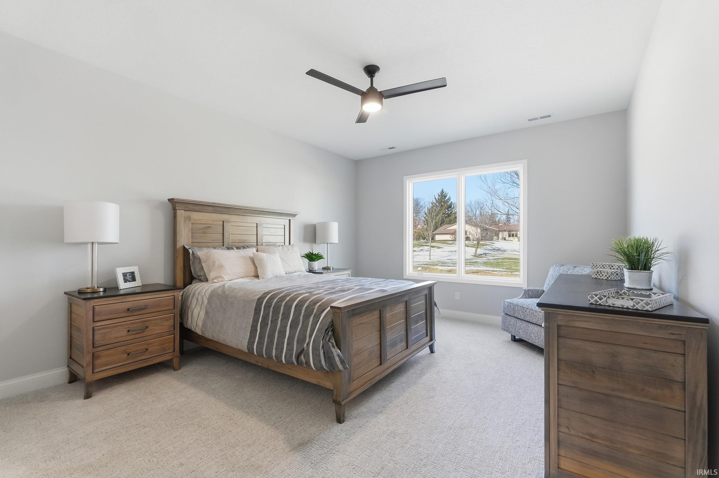 Bedroom featuring light colored carpet and a ceiling fan