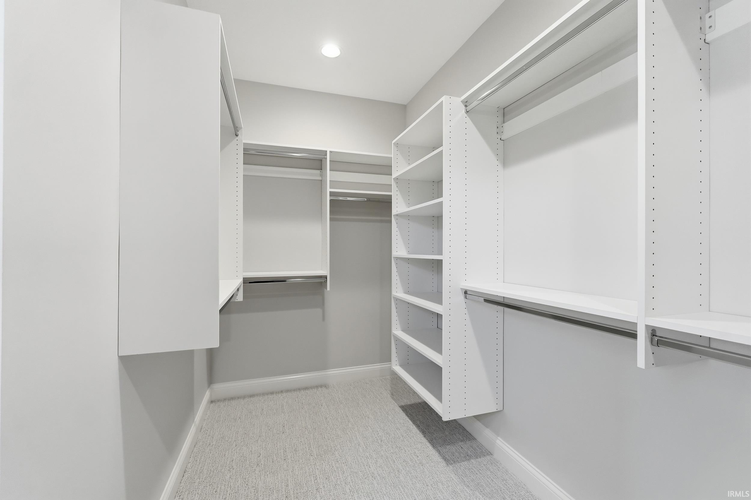 Walk in closet featuring light colored carpet