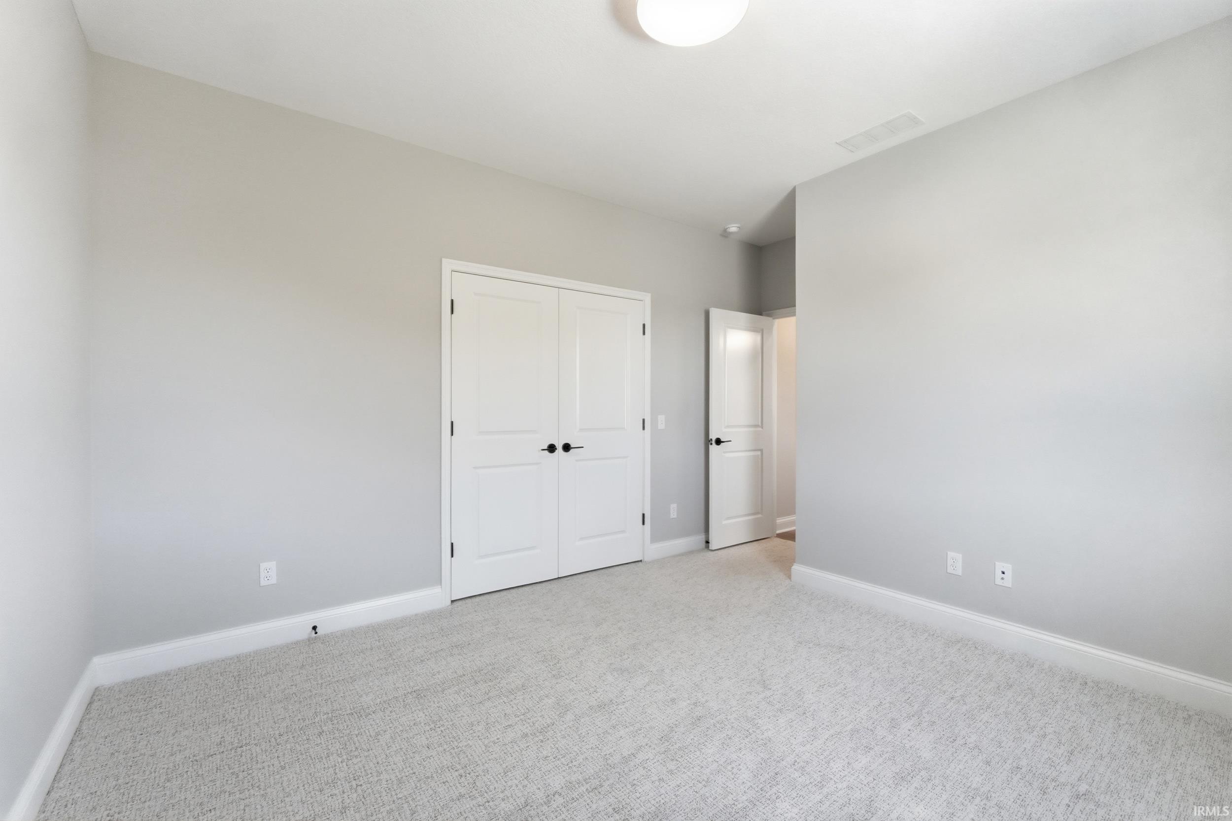 Unfurnished bedroom featuring carpet and a closet