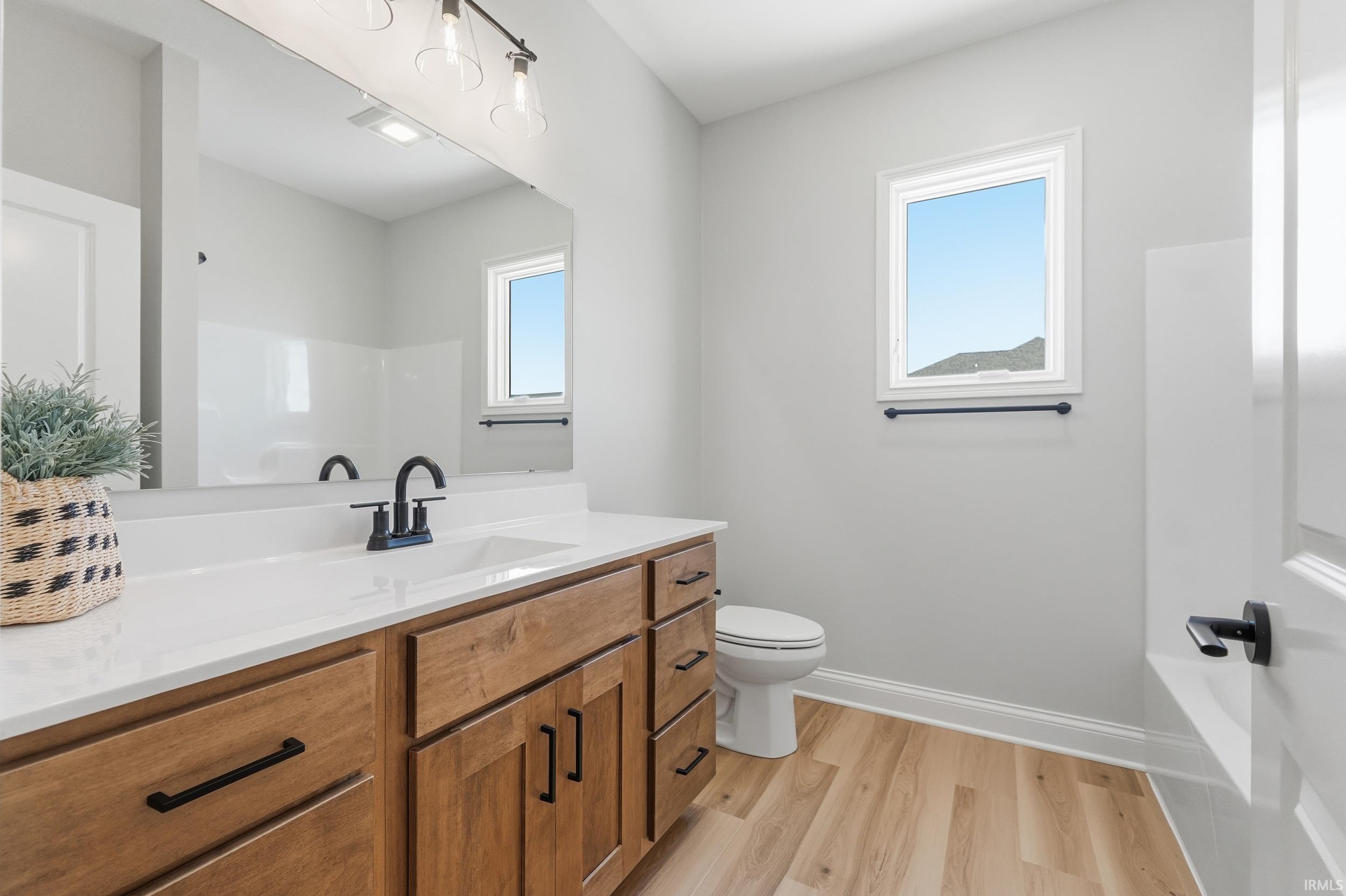 Full bath with vanity and light wood-type flooring