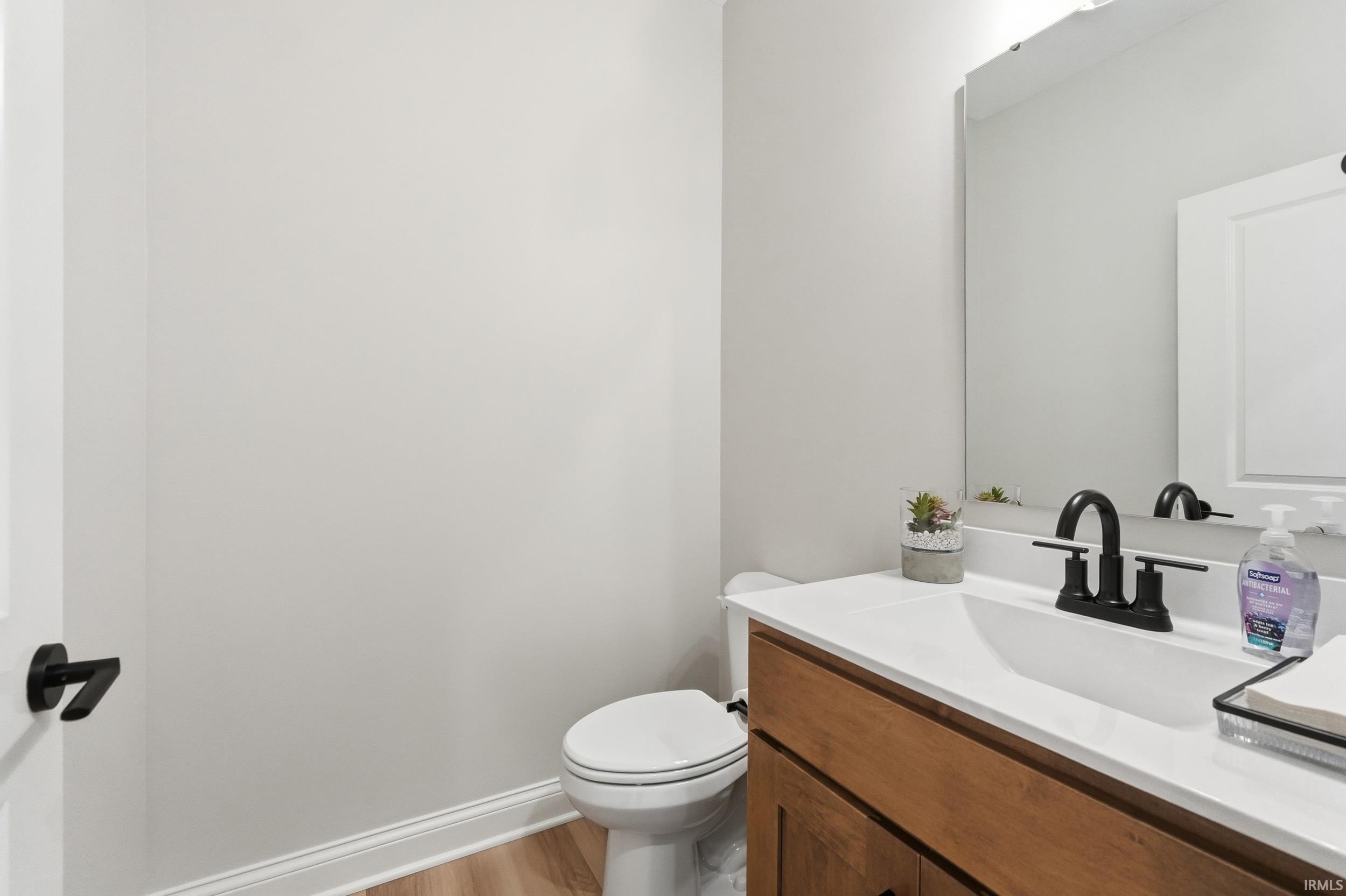 Half bath featuring vanity and light wood-style floors