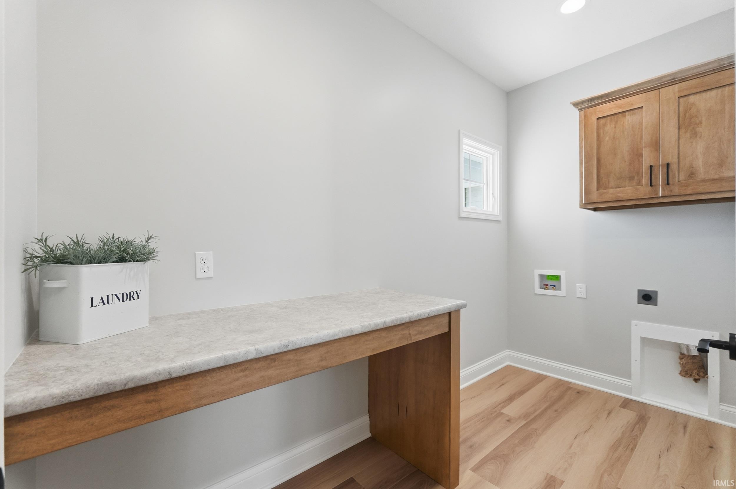 Laundry room with light wood finished floors, hookup for an electric dryer, hookup for a washing machine, an office area, and recessed lighting
