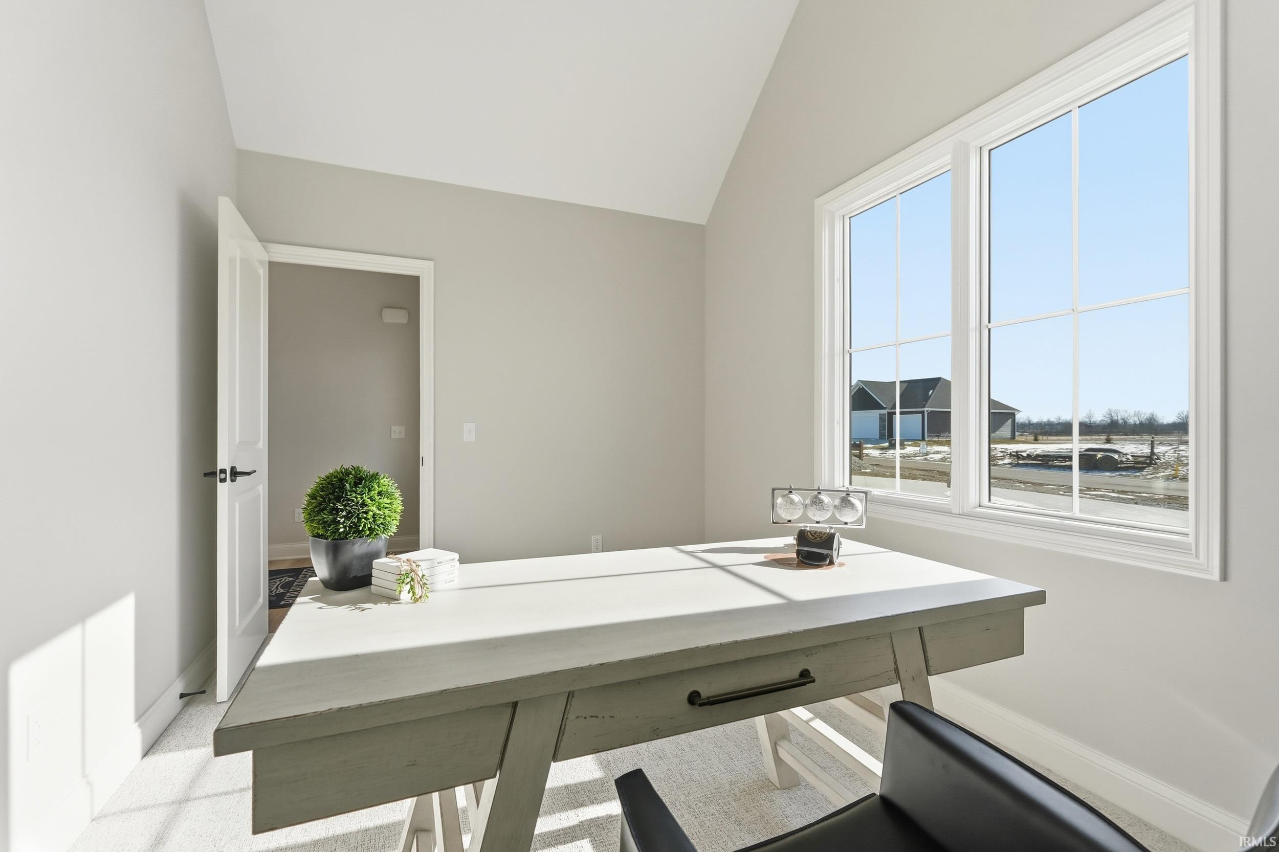 Office area featuring lofted ceiling and baseboards