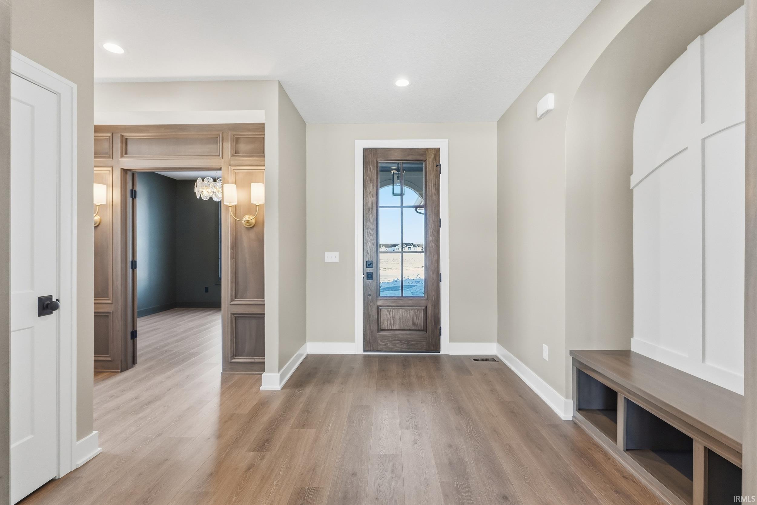 Foyer entrance with light wood finished floors and recessed lighting