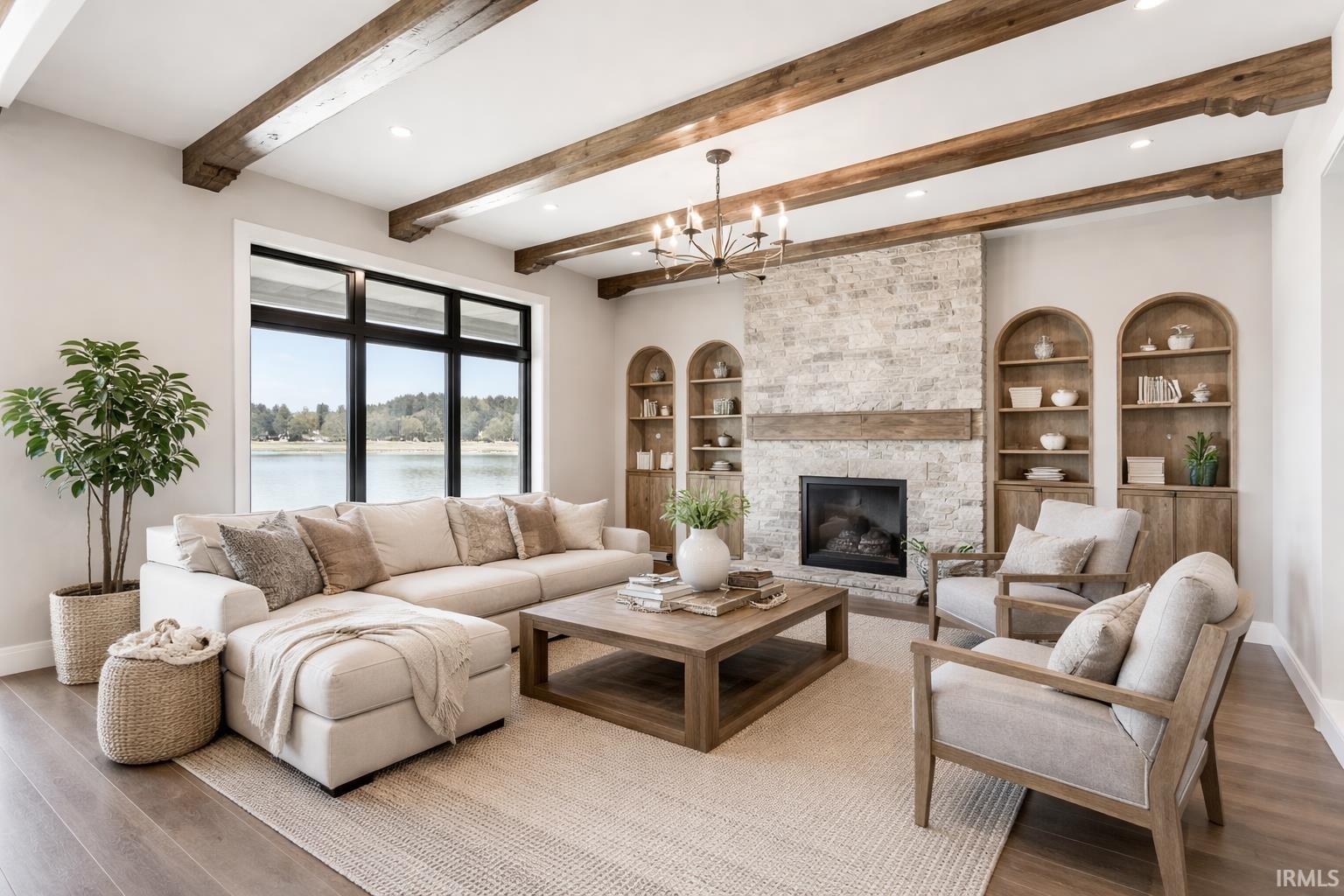 Staged By AI-Living room featuring wood finished floors, a large fireplace, a water view, a chandelier, and recessed lighting
