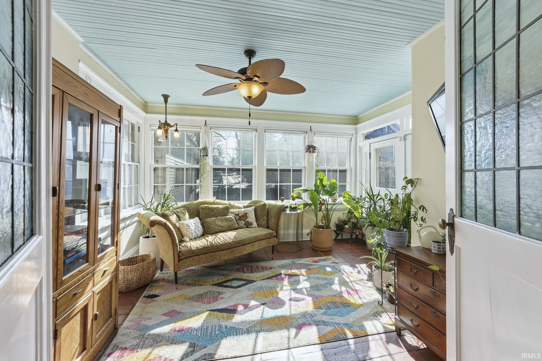 Sunroom with french doors, crown molding, and tile patterned floors