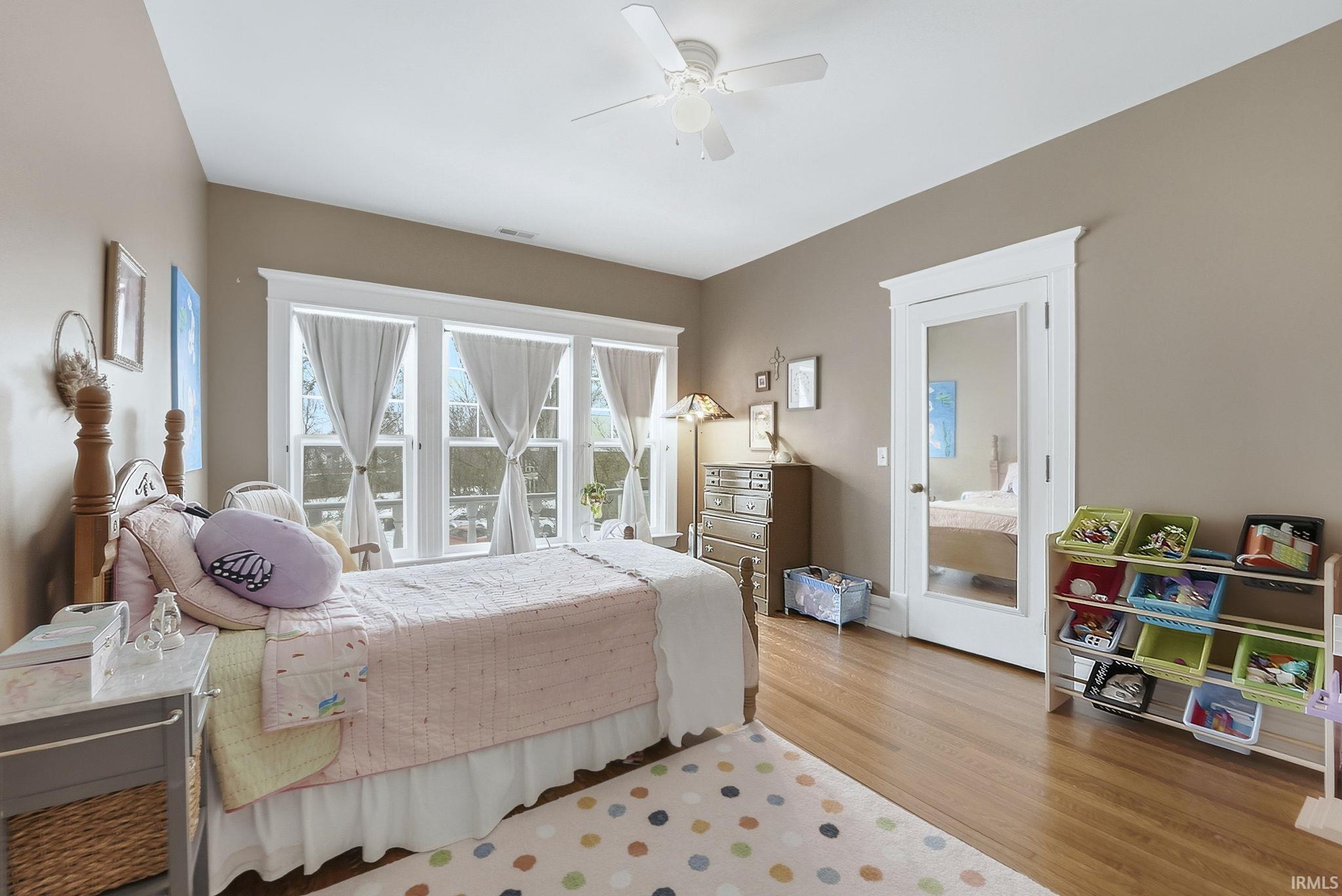 Bedroom with light wood-style floors and a ceiling fan