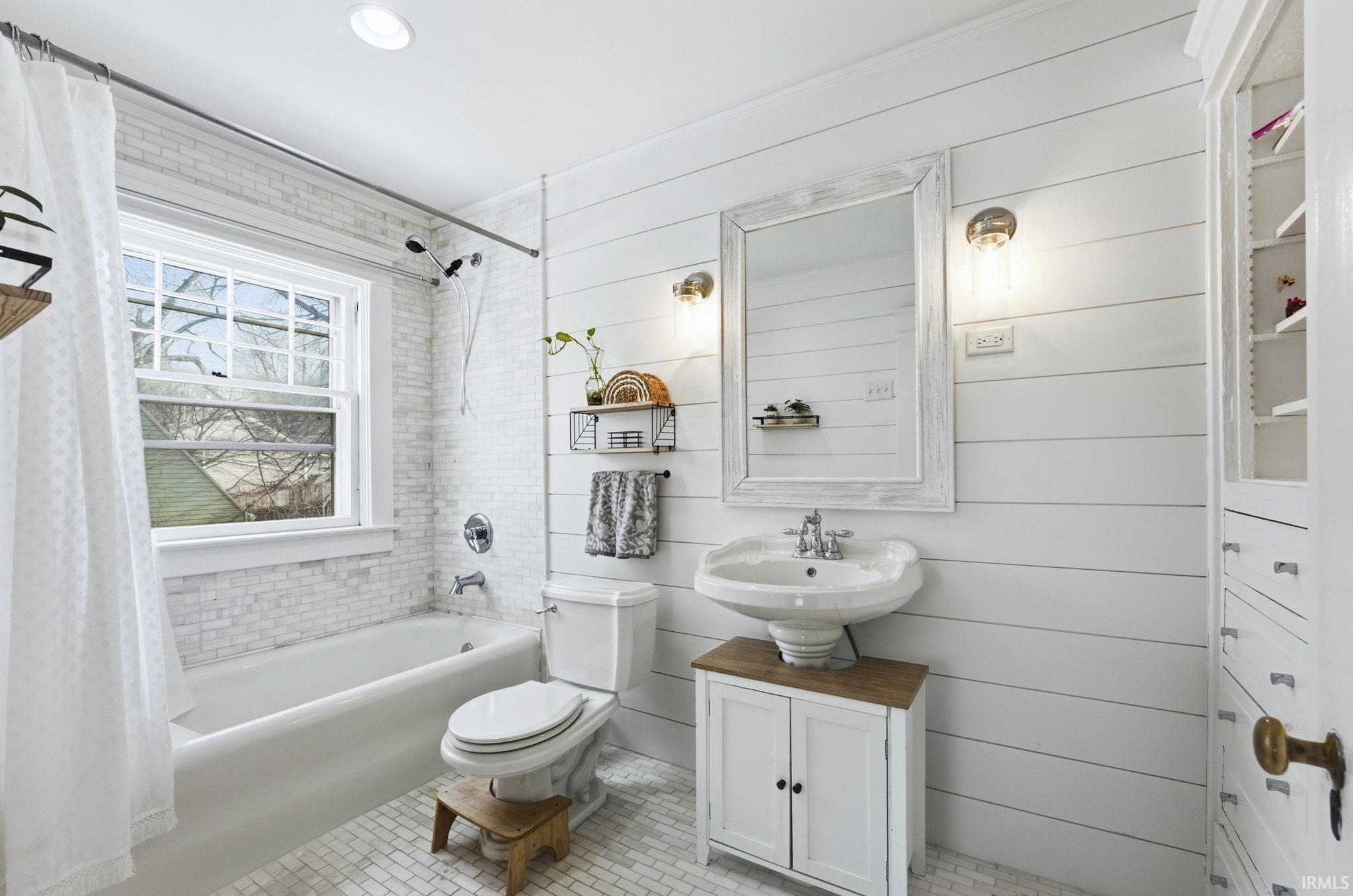 Full bath featuring shower / bathtub combination with curtain, vanity, wooden walls, light tile patterned flooring, and recessed lighting