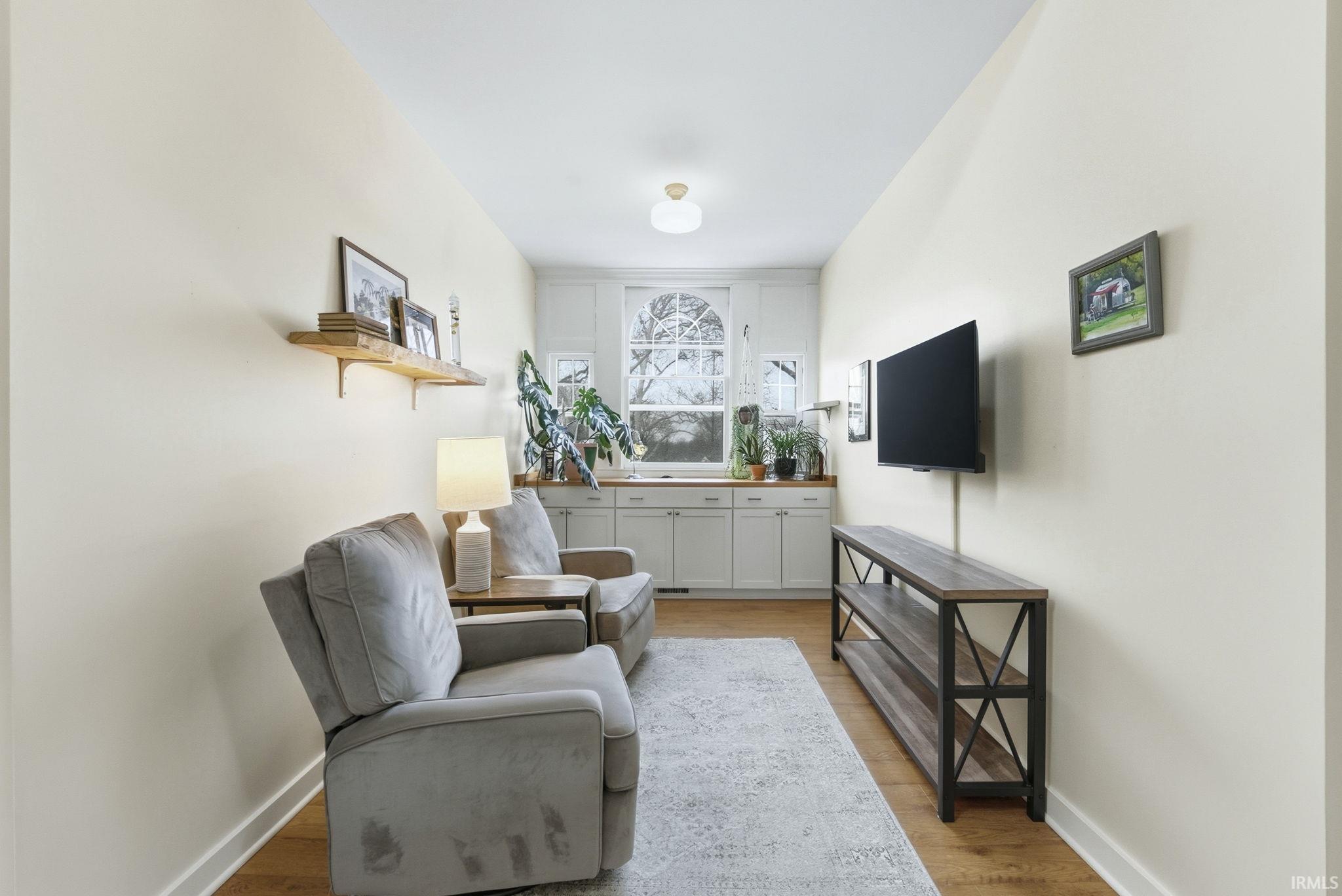 Living area with light wood finished floors and baseboards