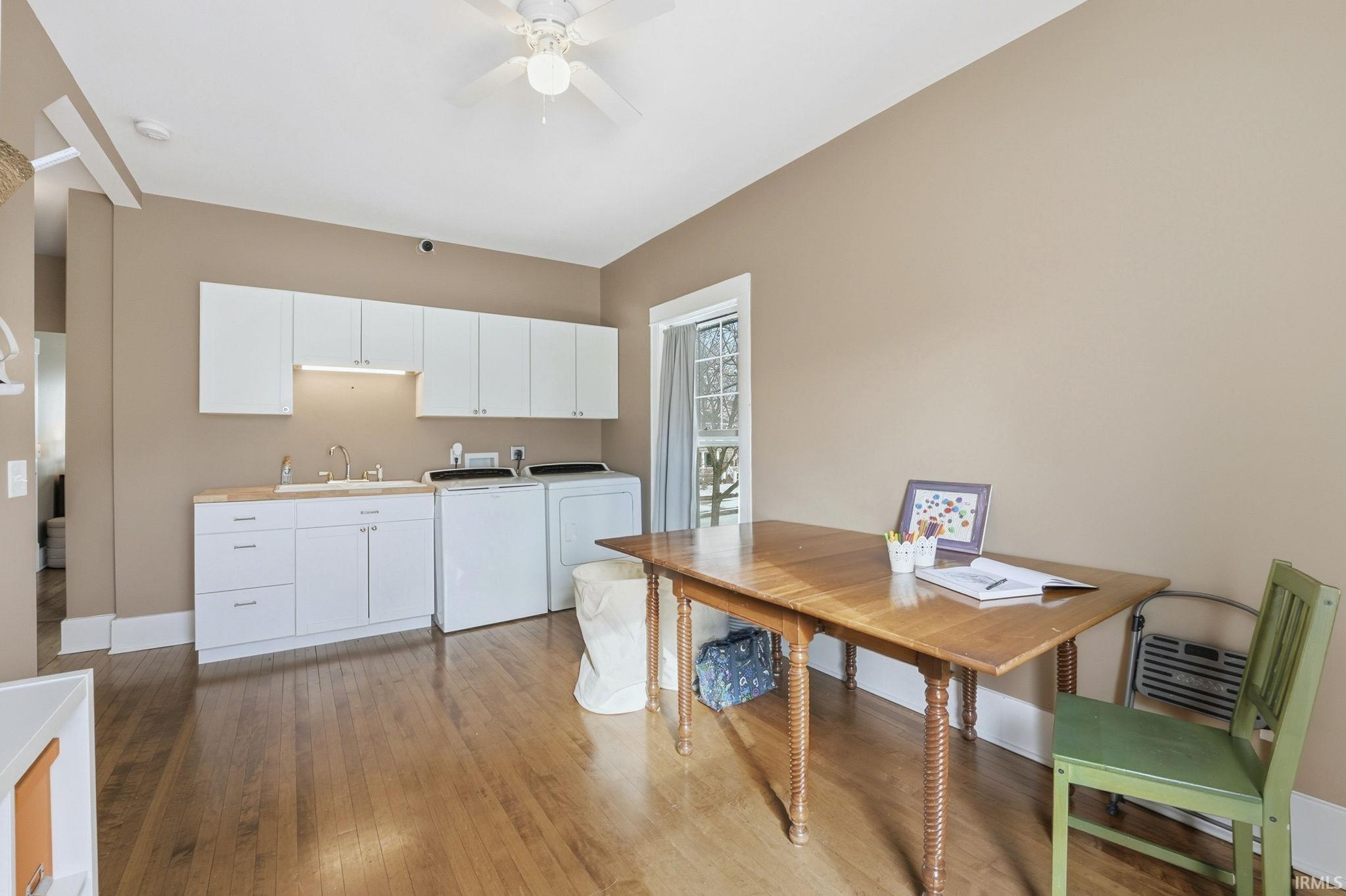 2nd floor laundry room, light wood-style floors, light countertops, separate washer and dryer, and a desk