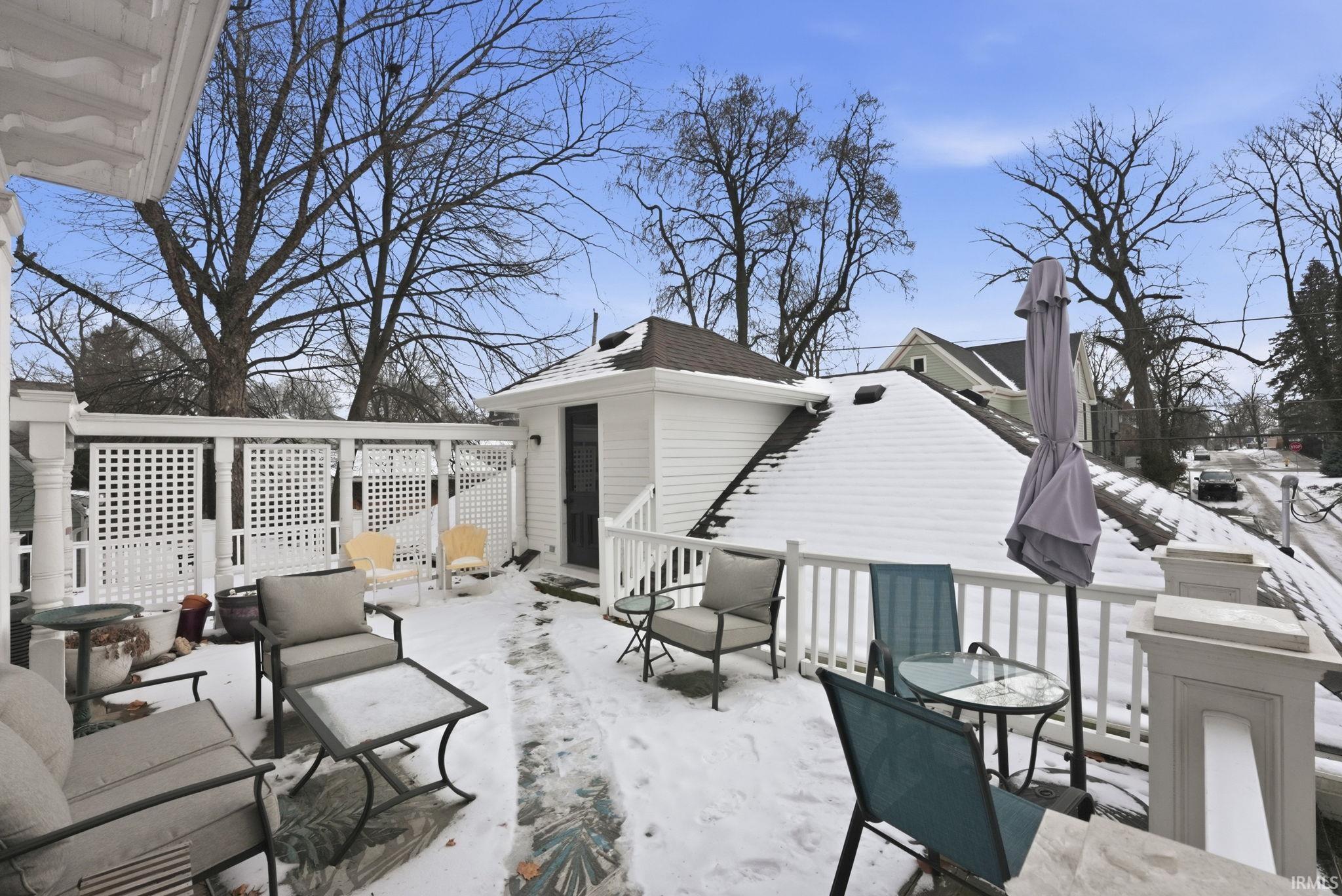Snow covered patio featuring a deck, an outbuilding, and outdoor lounge area