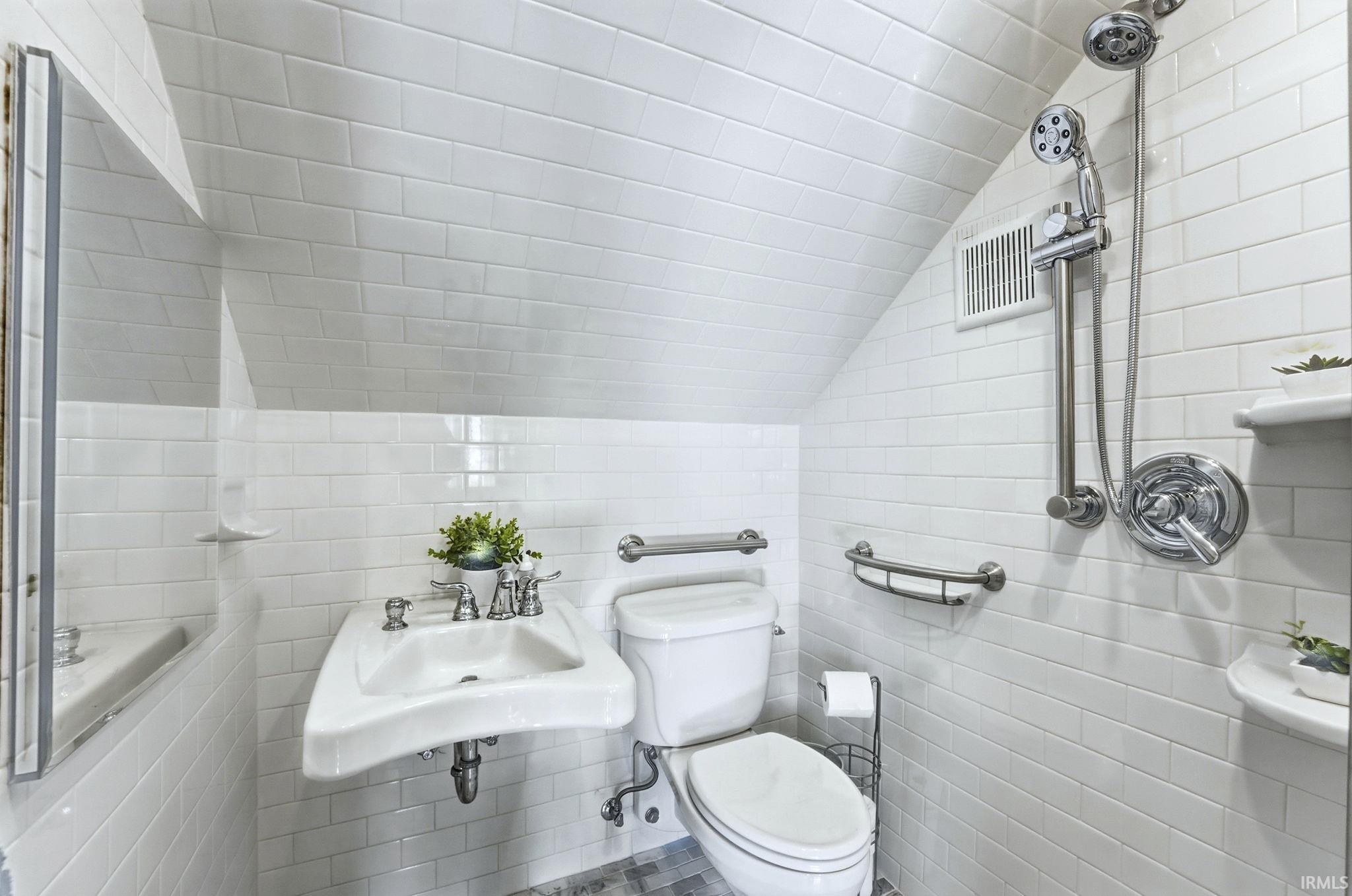 Bathroom on main level with tile walls and ceiling