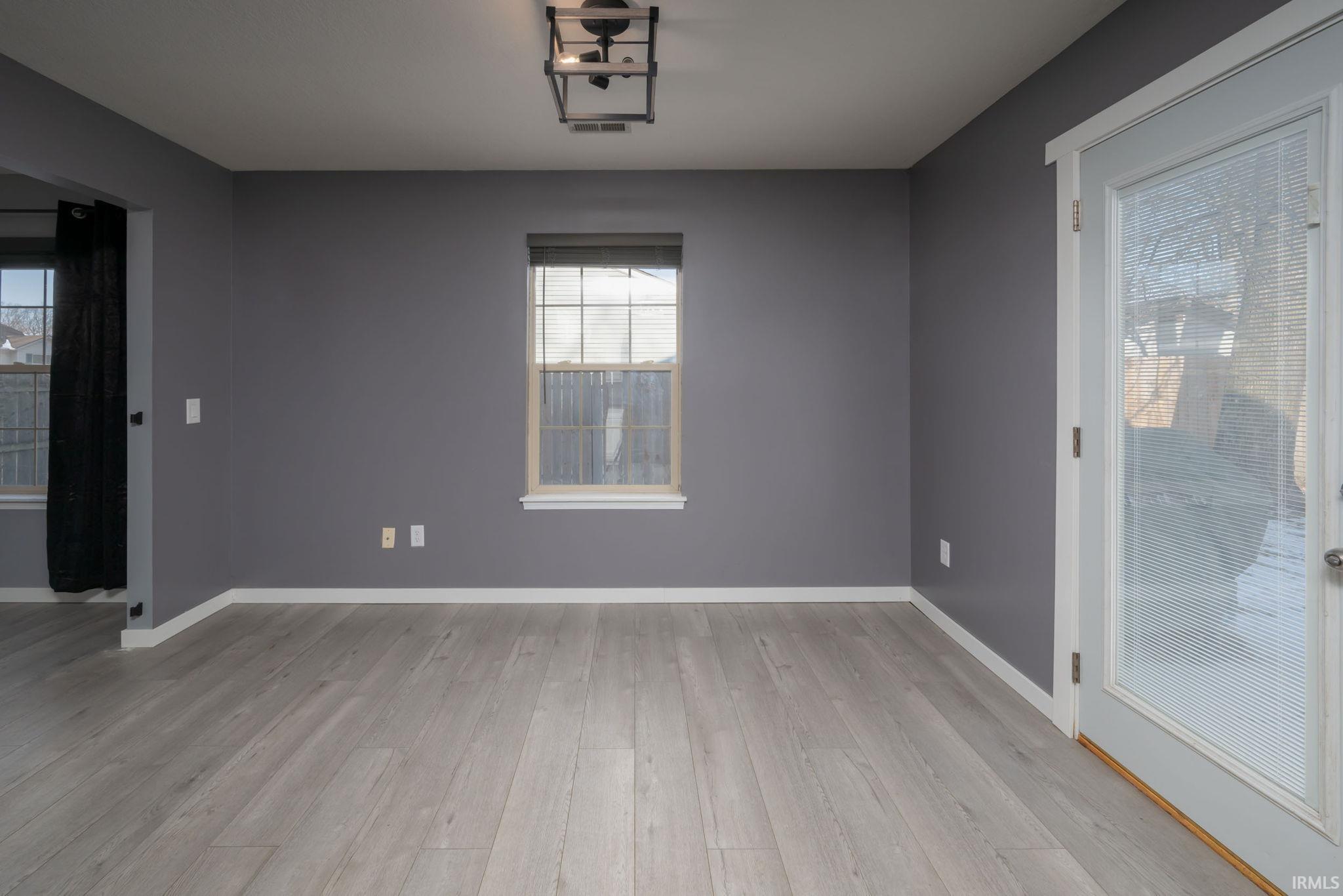 Unfurnished room featuring light wood finished floors and baseboards