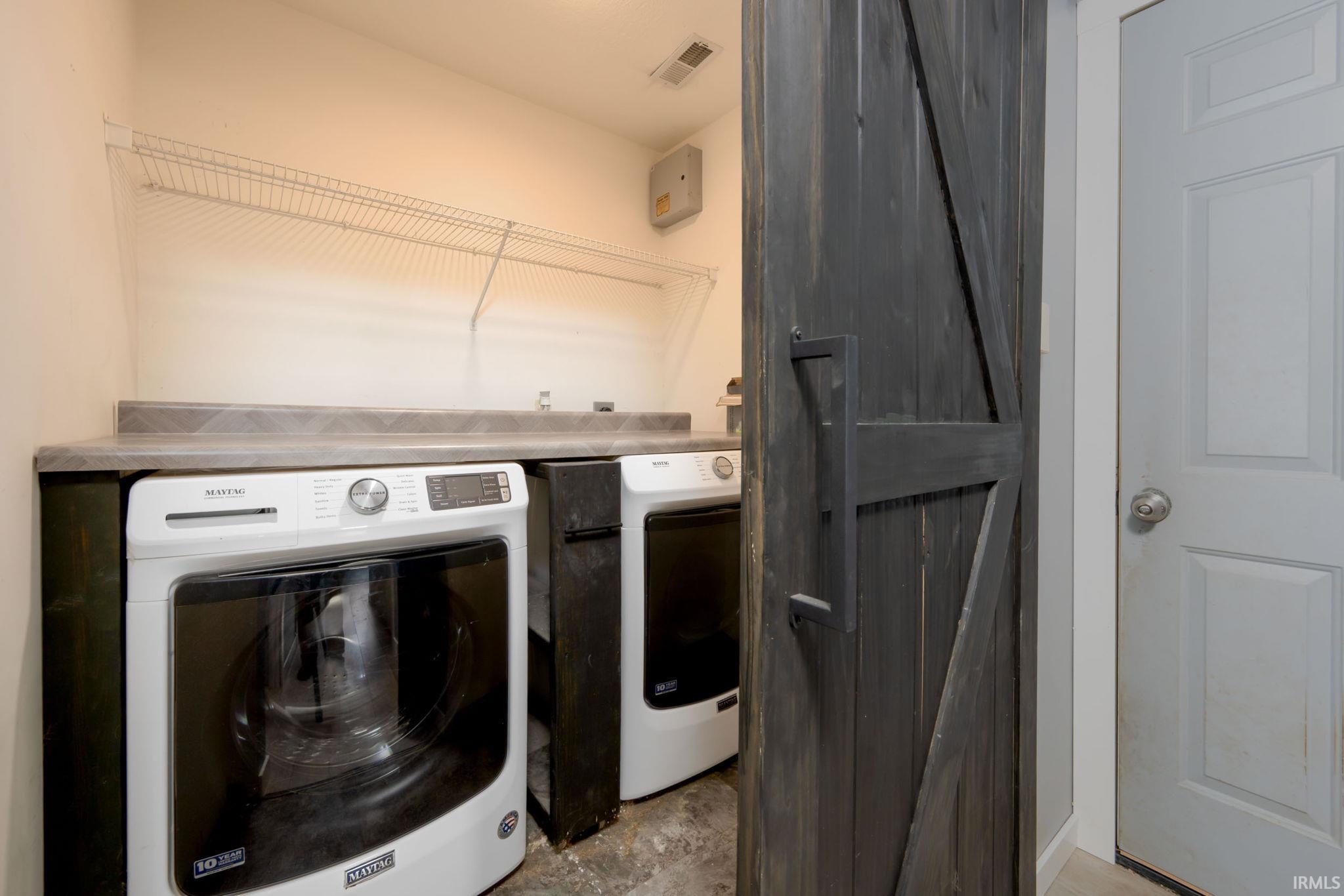 Washroom featuring a barn door and washer and clothes dryer