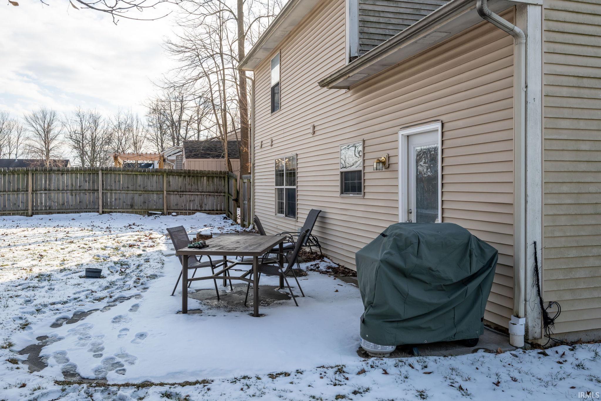 Snow covered patio with a patio area, a grill, and outdoor dining space