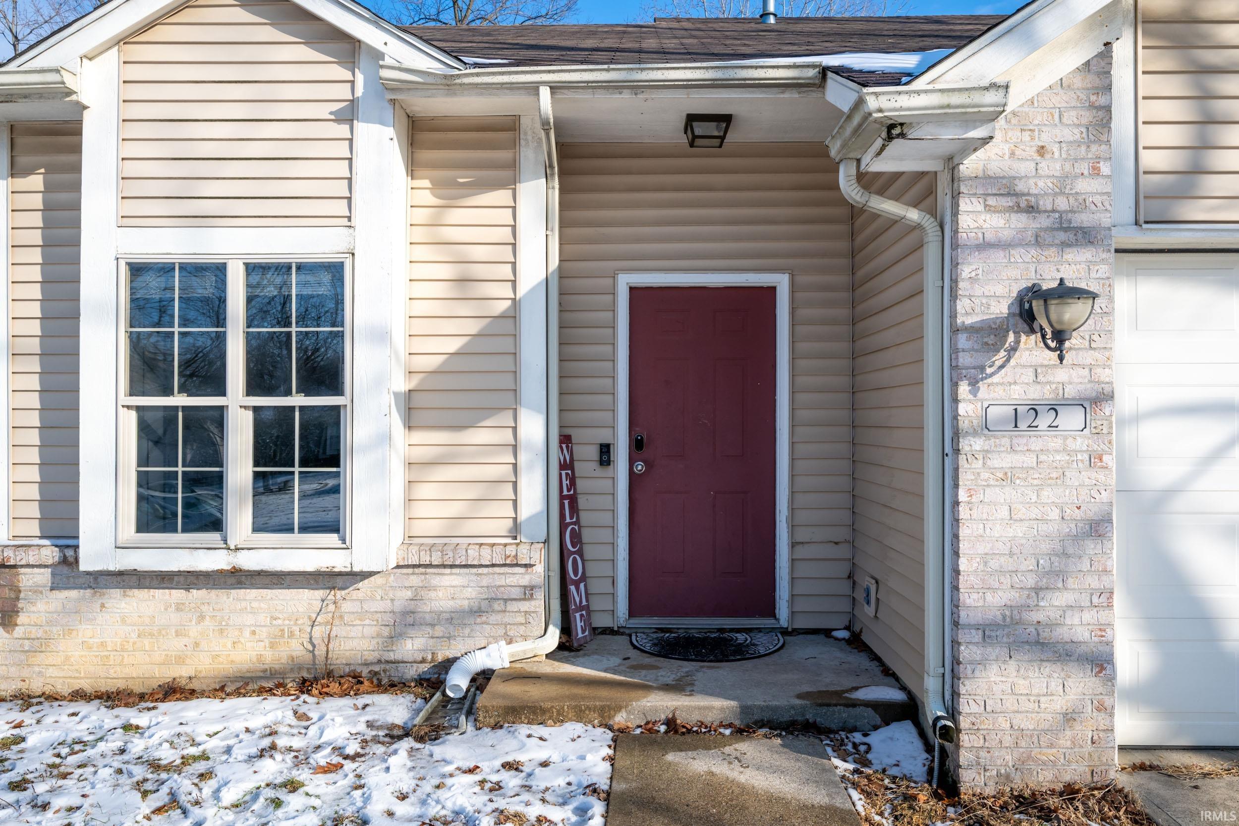 View of exterior entry with a shingled roof