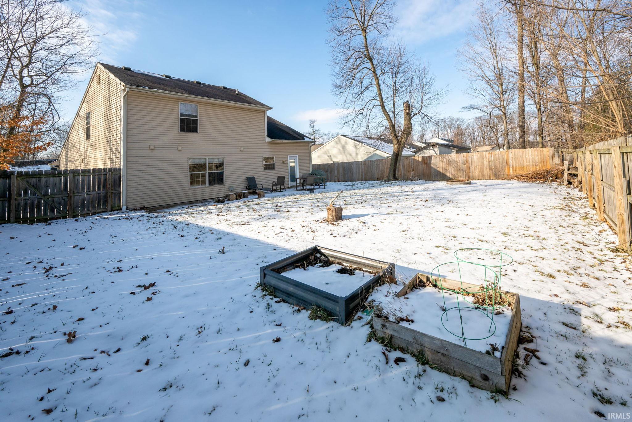 Snow covered property featuring a fenced backyard