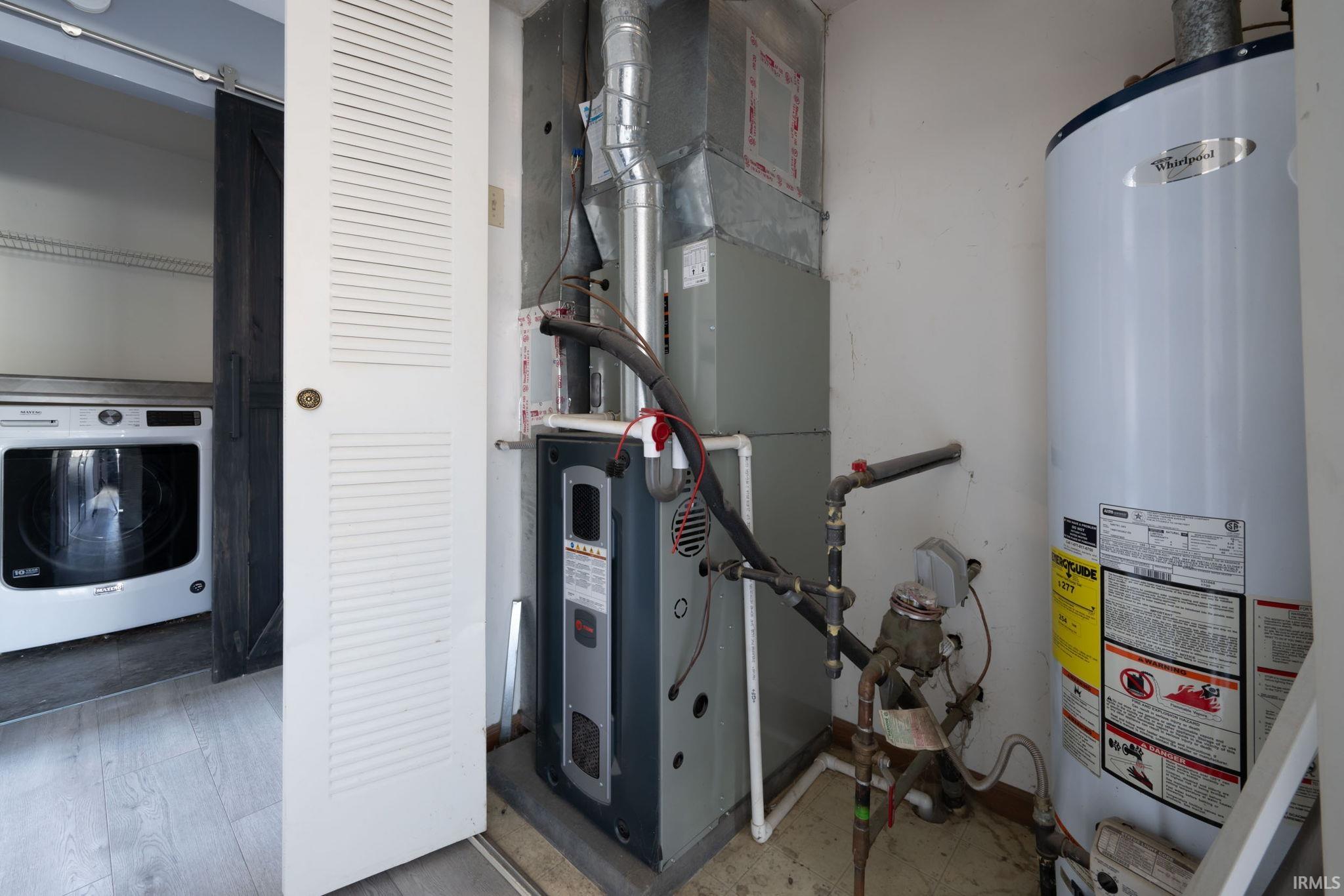Utility room featuring gas water heater, washer / clothes dryer, and heating unit