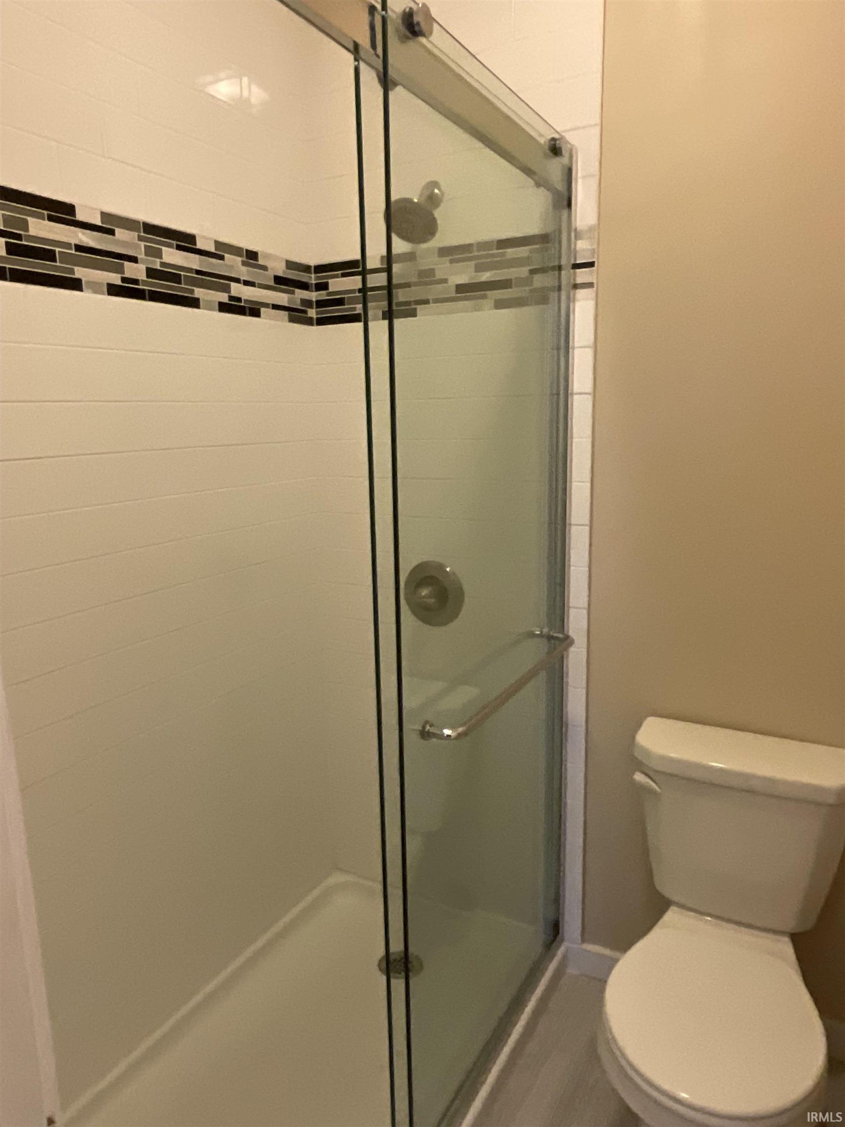 Bathroom with a stall shower and toilet