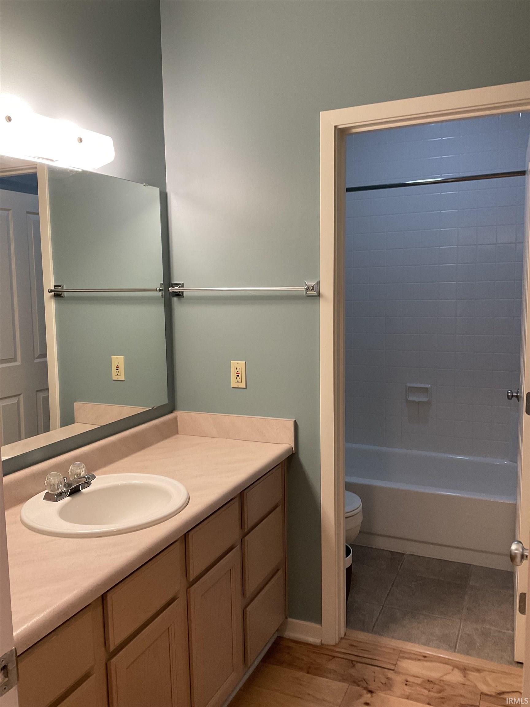 Full bathroom featuring vanity, shower / bath combination, and light wood-style floors, accessible from the hall or the second bedroom