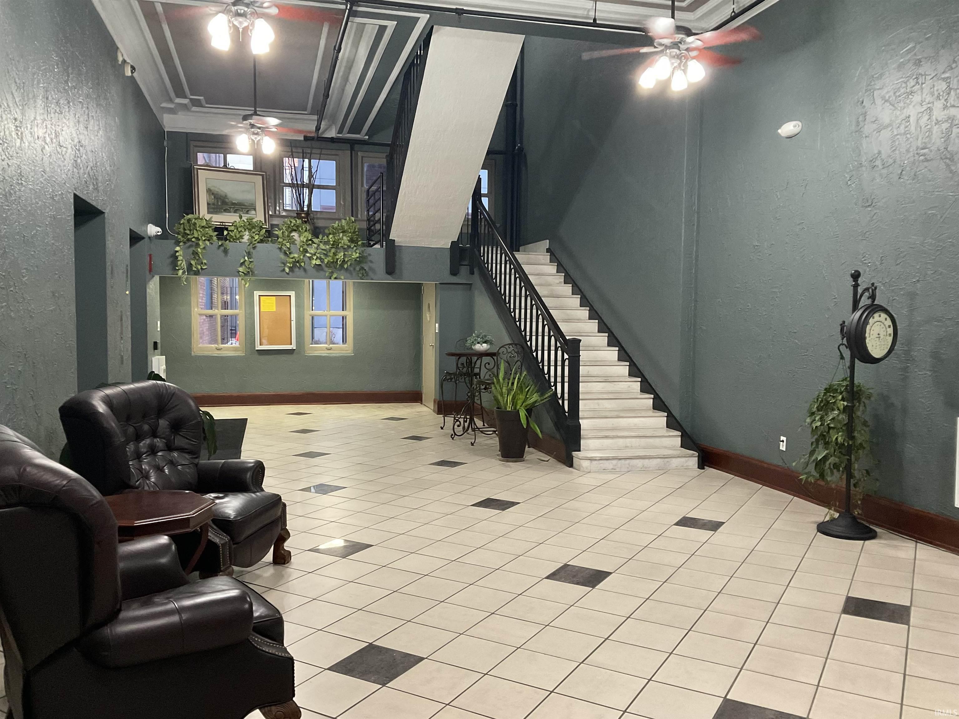 Community lobby with a textured wall, a towering ceiling, and stairs