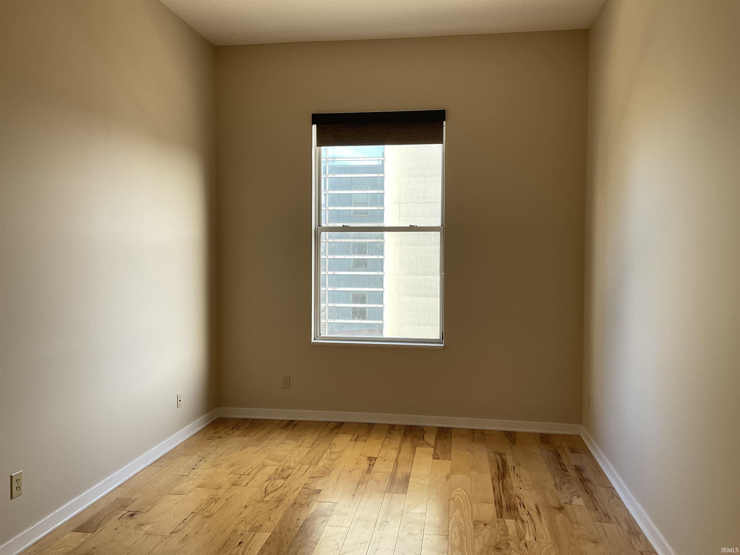 Unfurnished room featuring light wood-style floors and baseboards