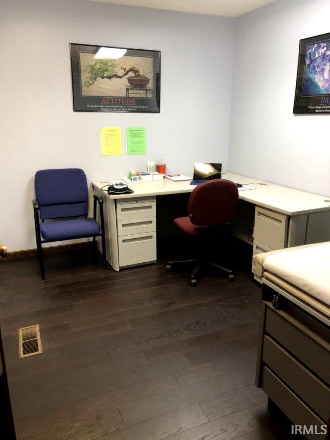Office space featuring built in desk and dark wood finished floors