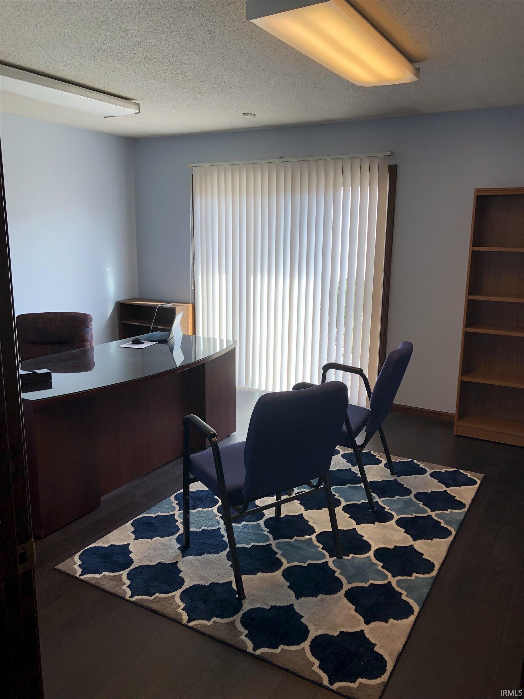Office featuring a textured ceiling and dark wood-style flooring