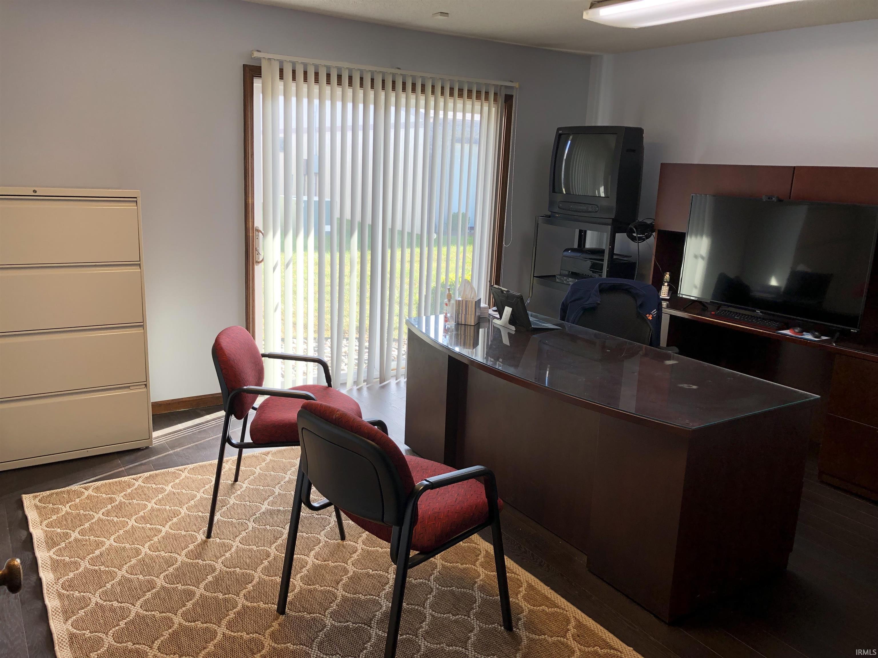Office with dark wood-style floors and baseboards