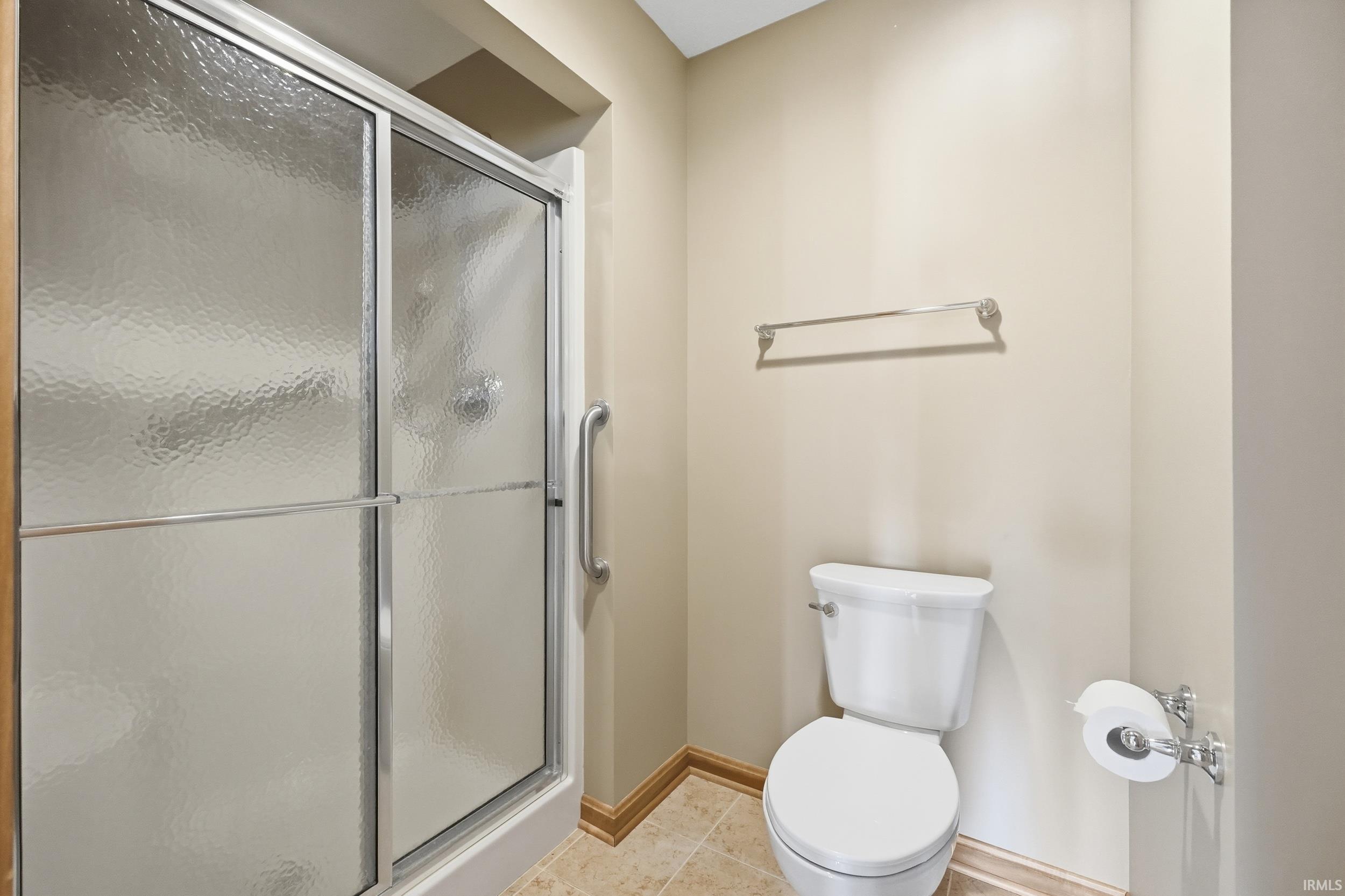 Bathroom with a stall shower and light tile patterned flooring