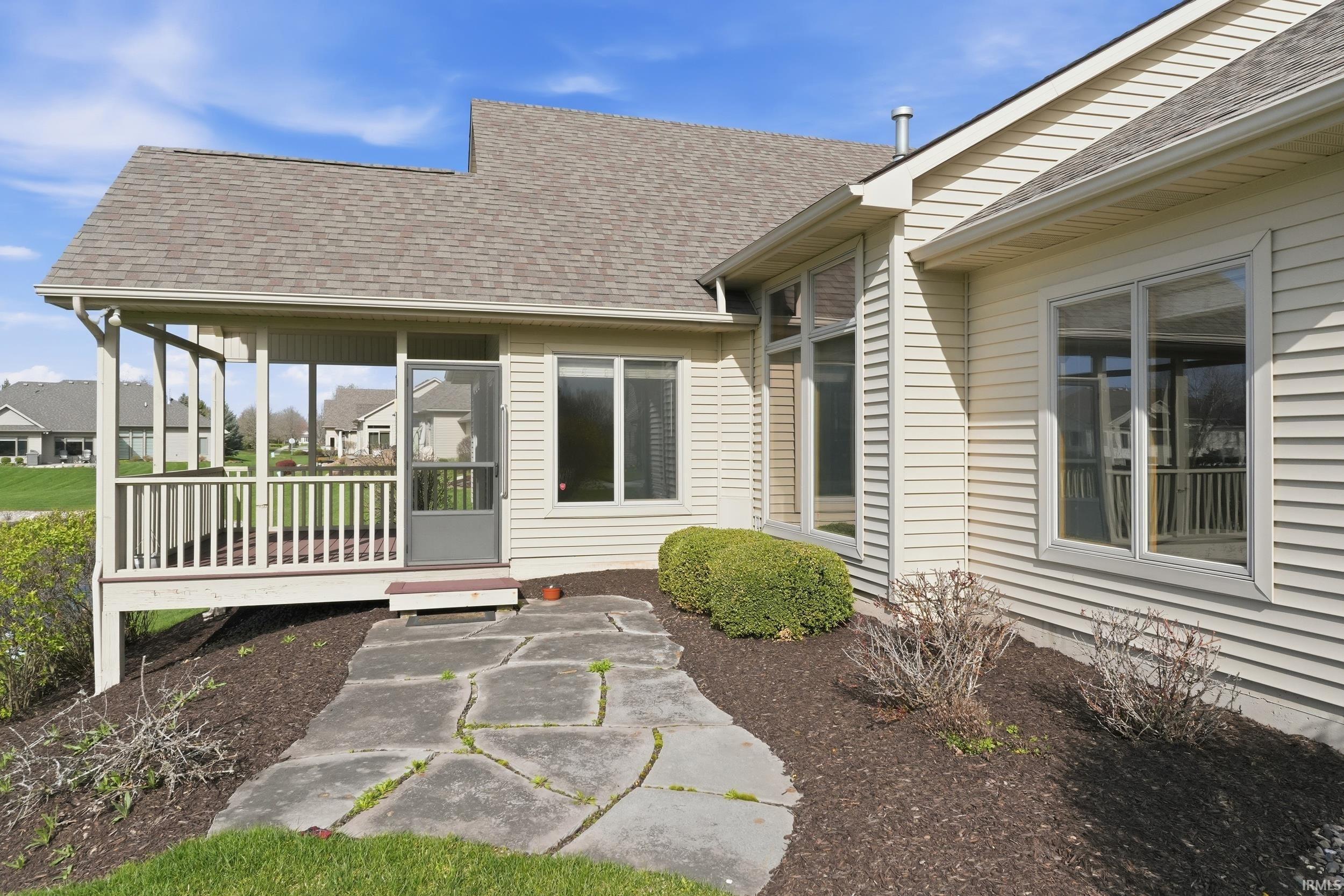 Rear view of property with a shingled roof and a sunroom