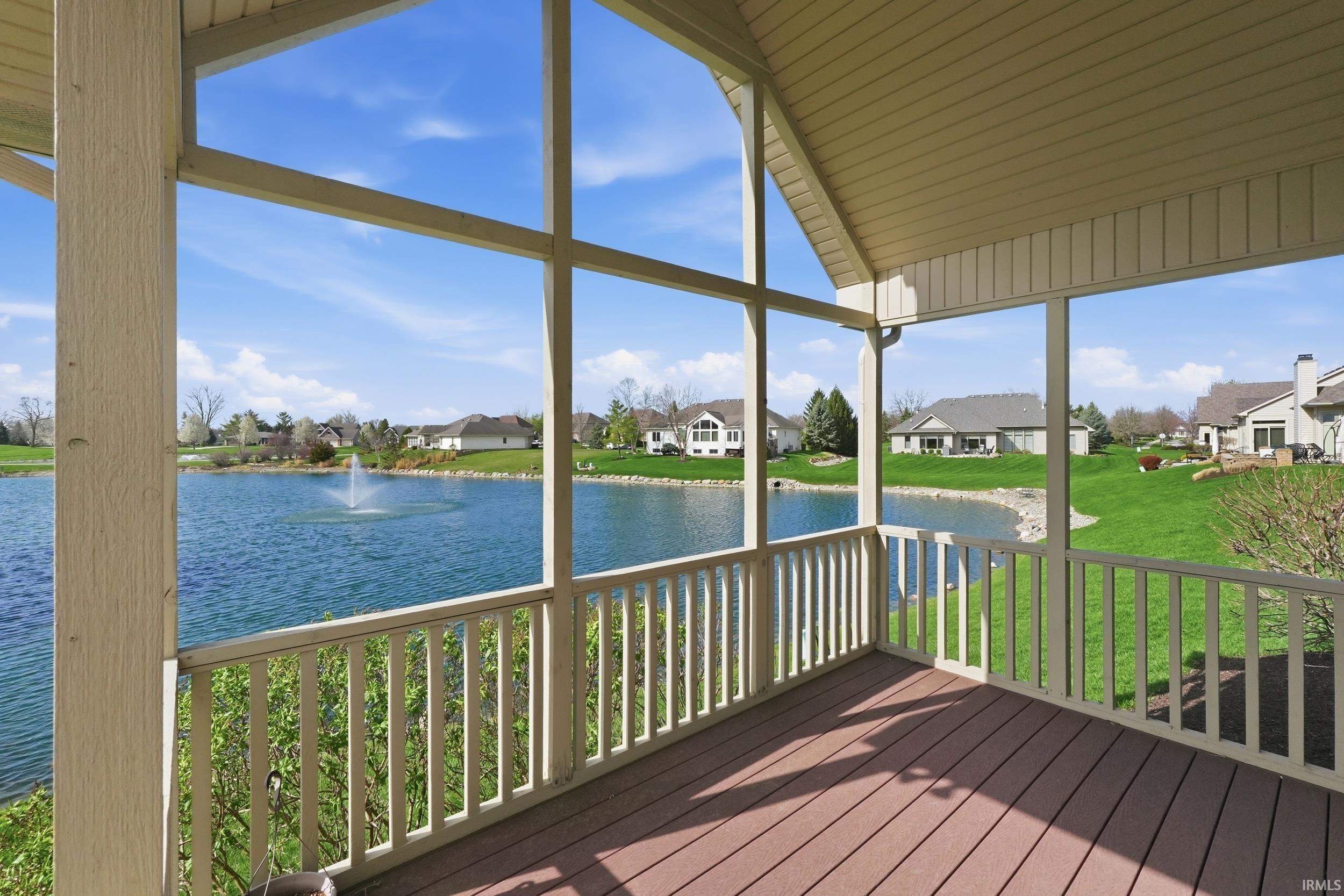 Deck featuring a water view, a sunroom, a residential view, and a lawn