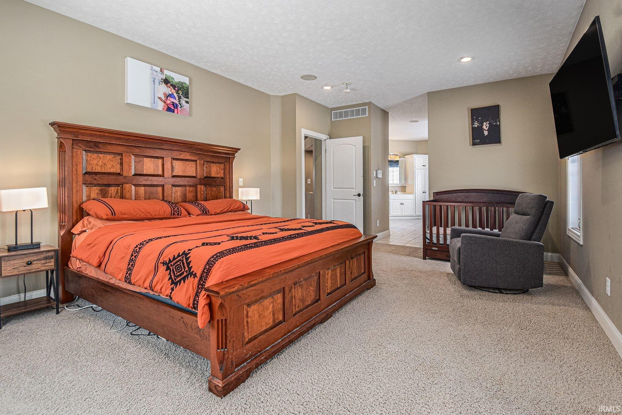 Bedroom featuring light carpet and a textured ceiling