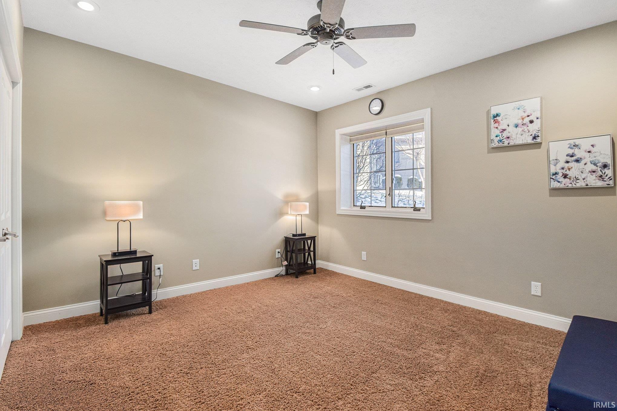 Spare room featuring carpet flooring, a ceiling fan, and recessed lighting