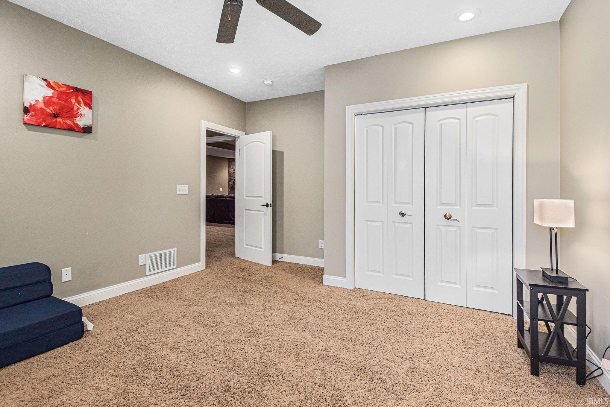 Sitting room with light colored carpet and recessed lighting