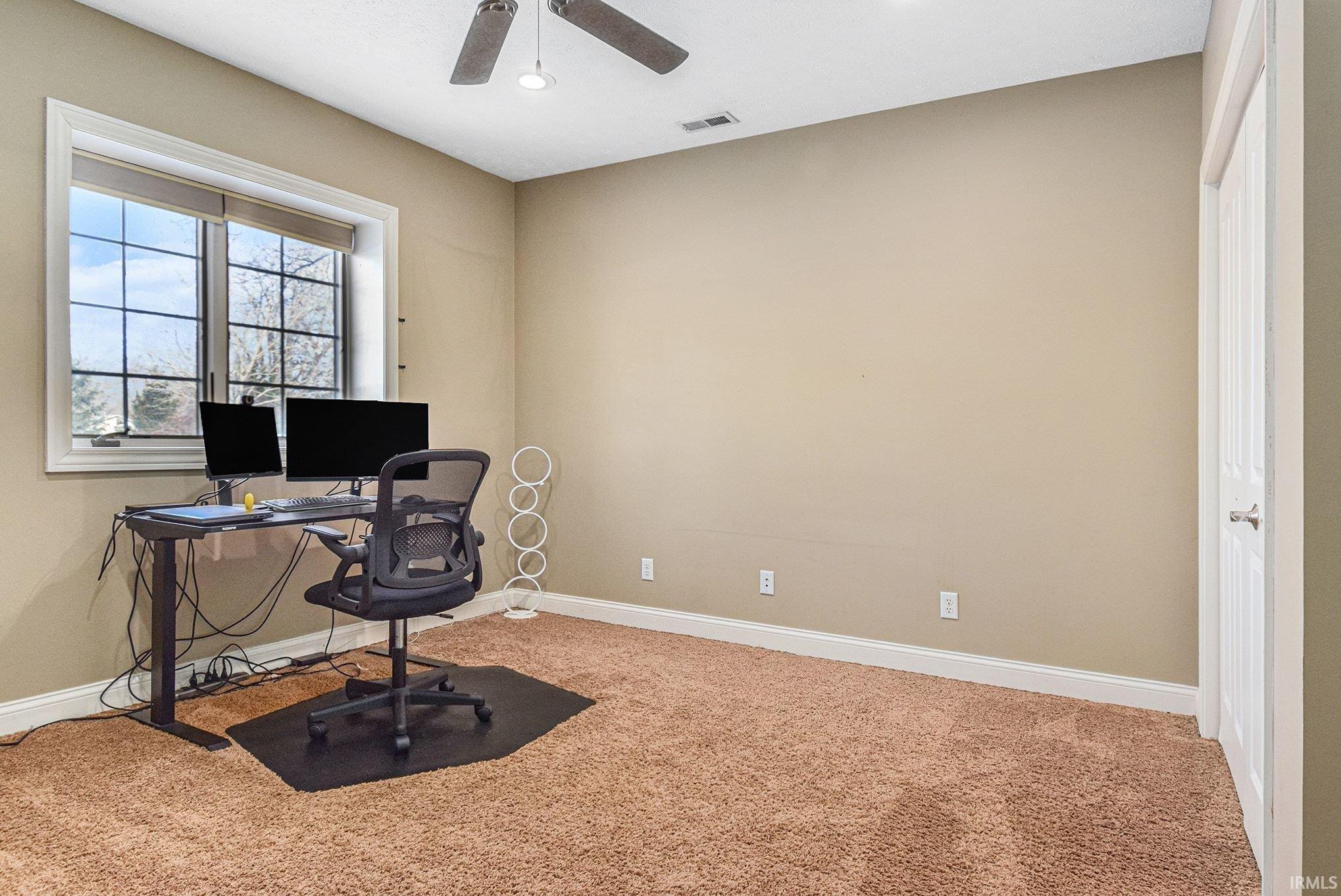 Carpeted office space featuring baseboards and recessed lighting