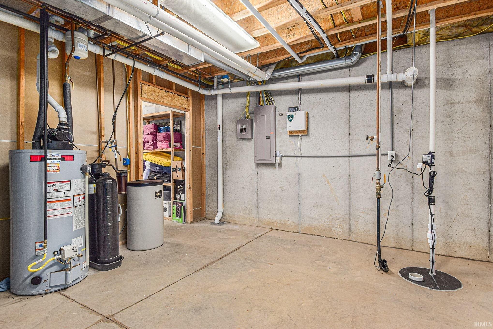 Unfinished below grade area with electric panel, a water softener, and gas water heater