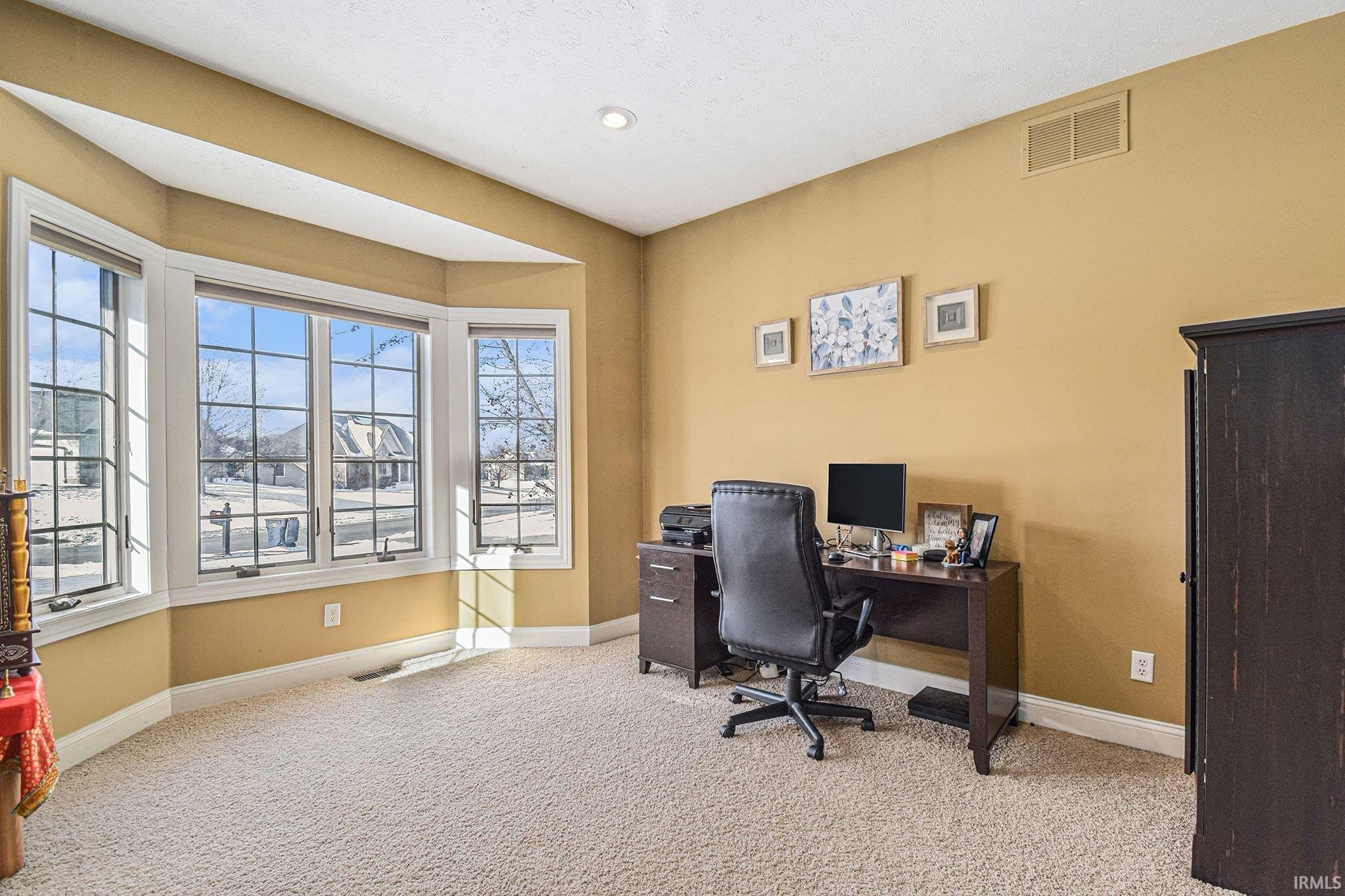 Office with baseboards and light carpet