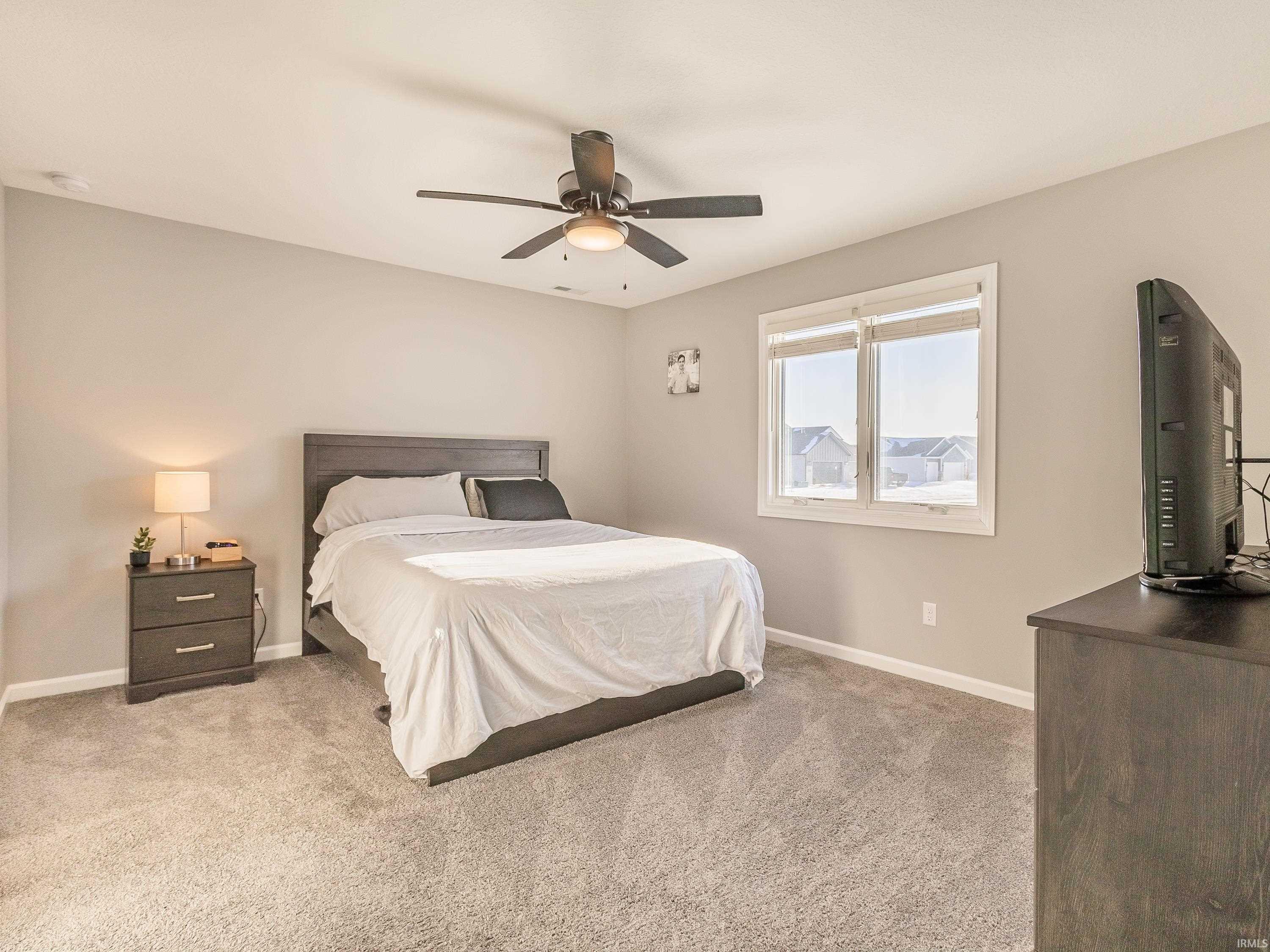 Bedroom with light carpet and ceiling fan