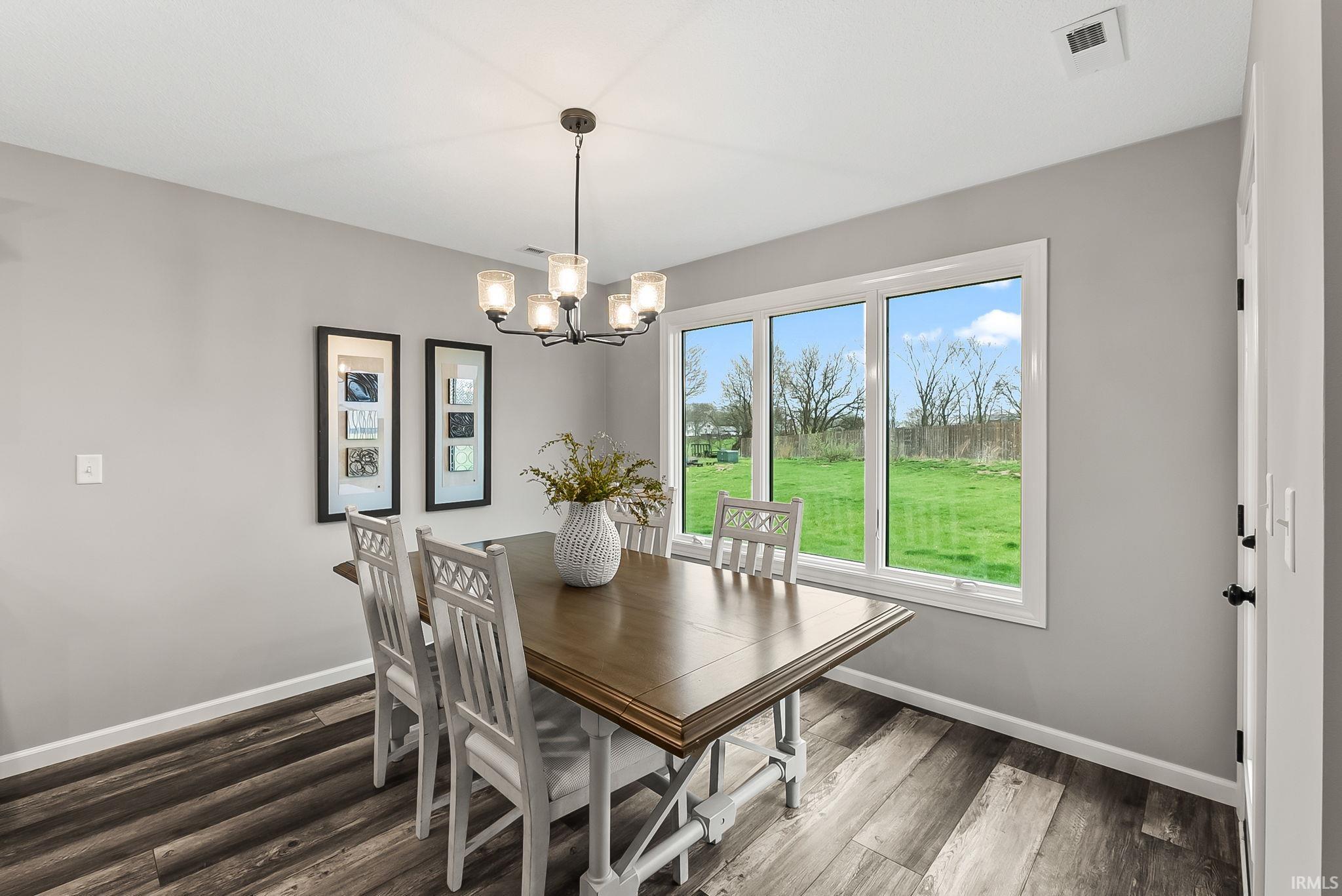 Dining space featuring wood finished floors and a chandelier