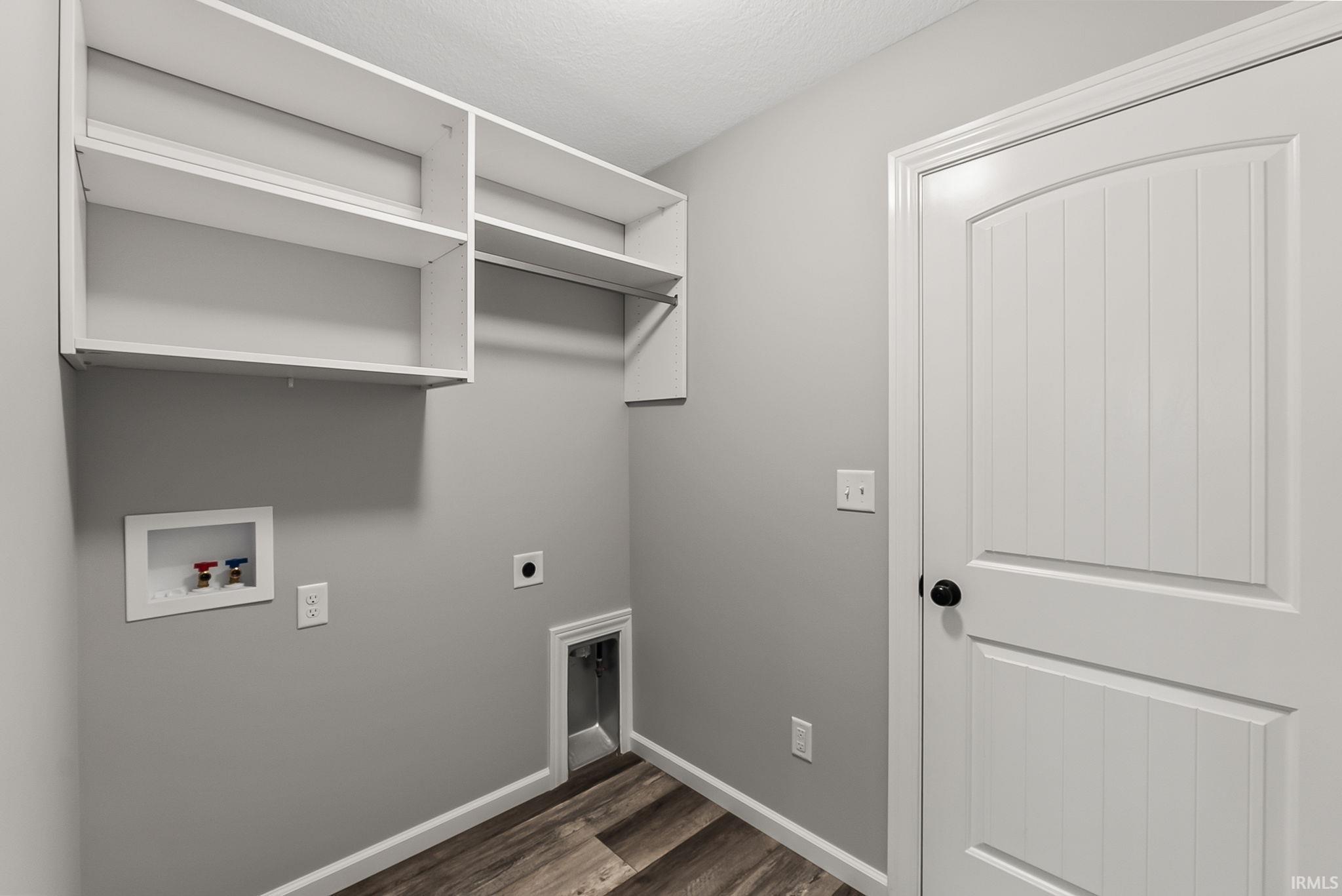 Laundry area with dark wood-type flooring, hookup for an electric dryer, and hookup for a washing machine
