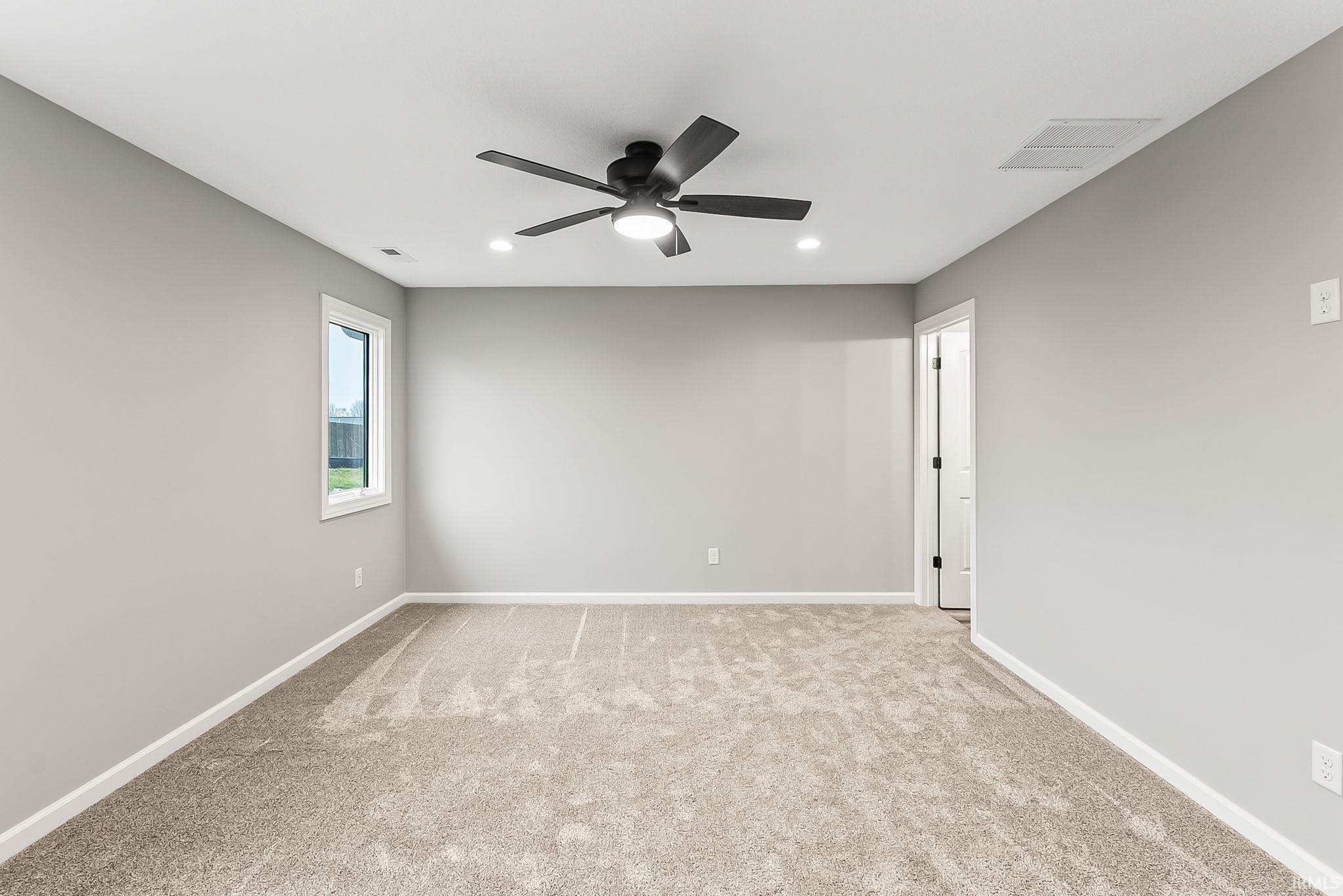 Spare room with a ceiling fan, light colored carpet, and recessed lighting