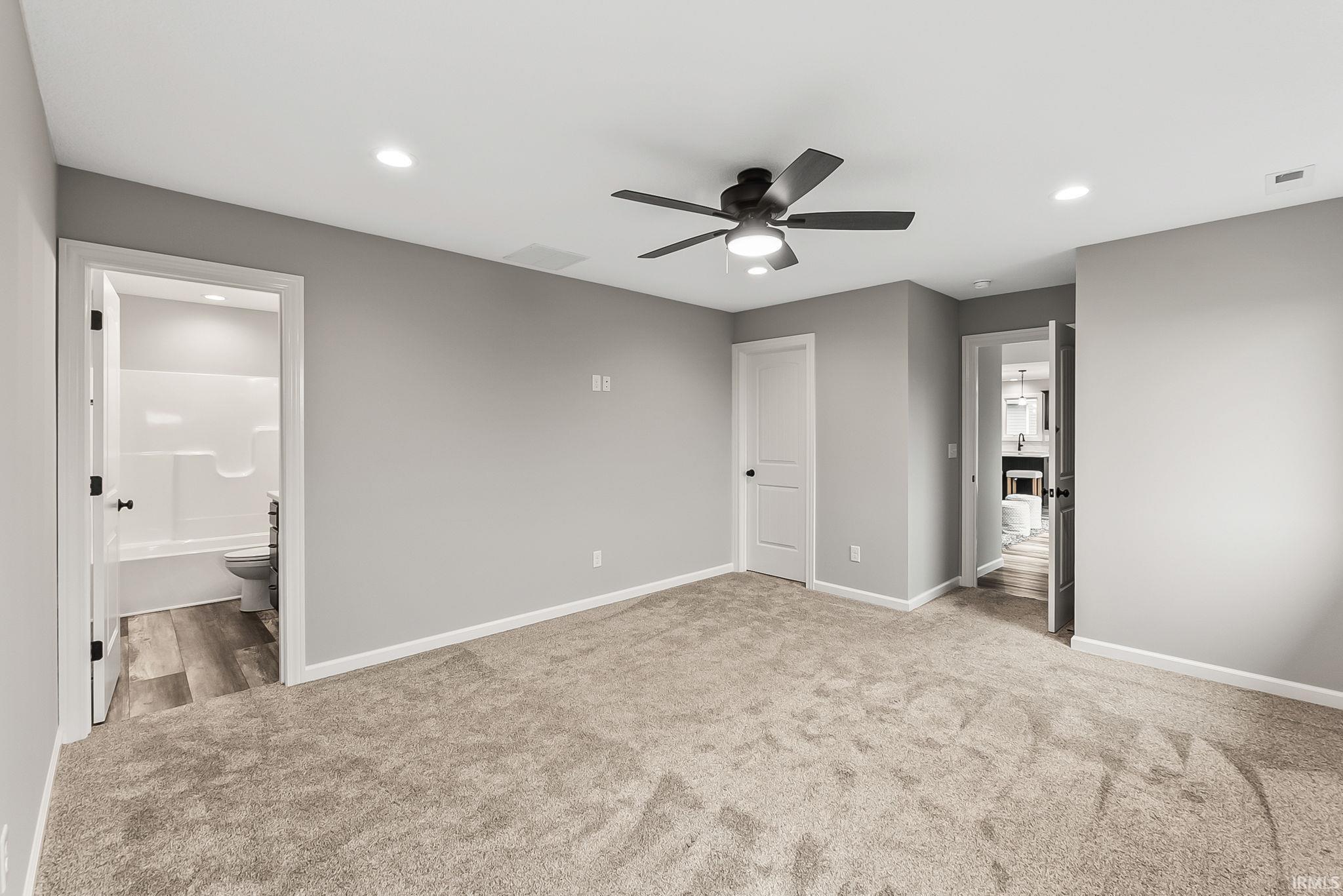 Unfurnished bedroom with recessed lighting, light carpet, ceiling fan, and ensuite bathroom