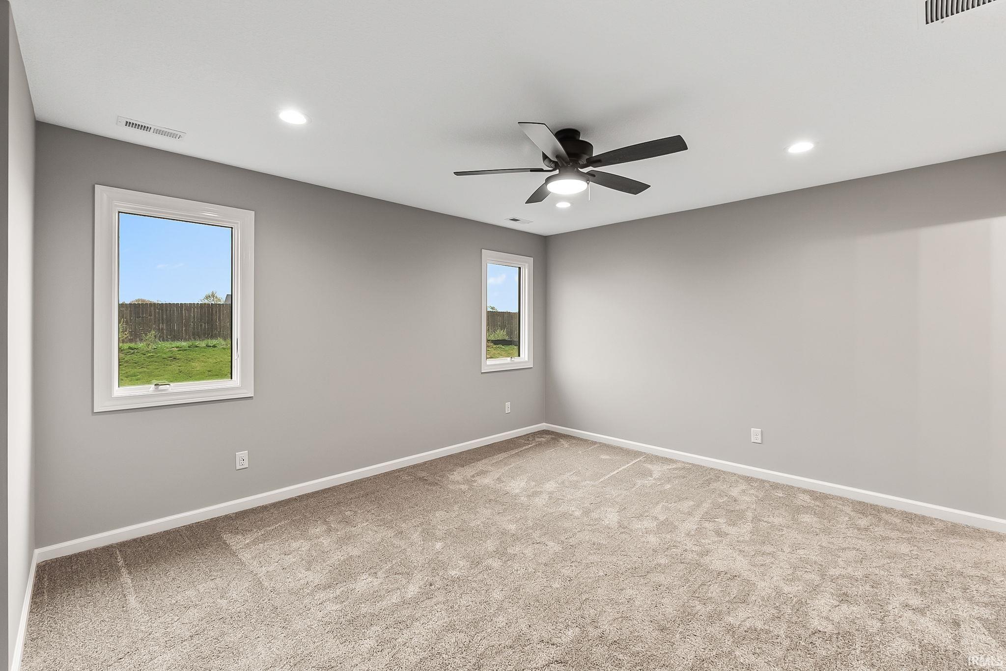 Unfurnished room featuring light carpet, a ceiling fan, and recessed lighting