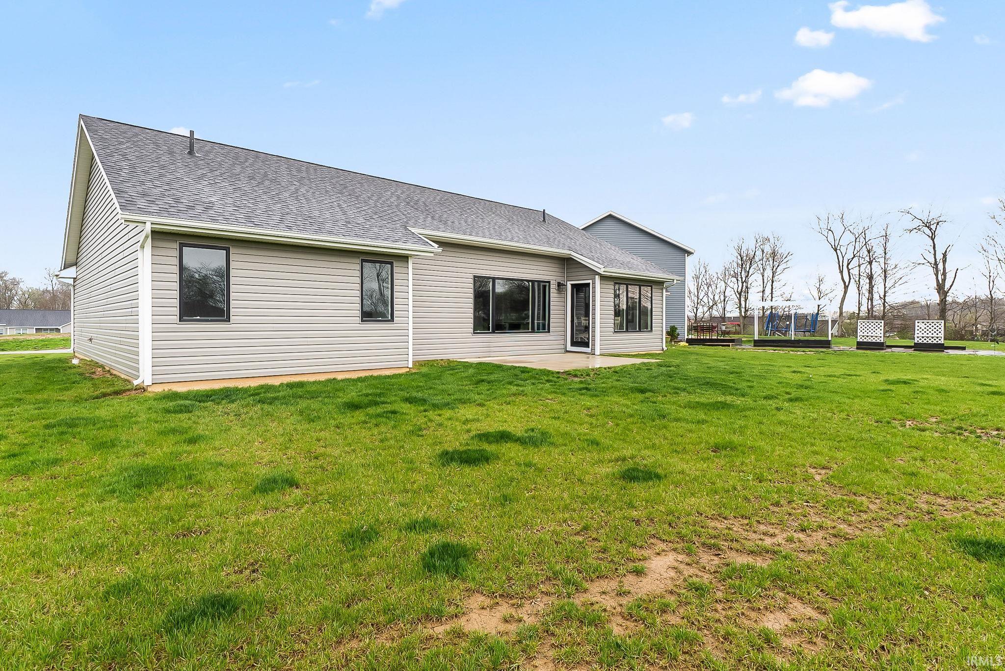 Rear view of property with a yard and roof with shingles