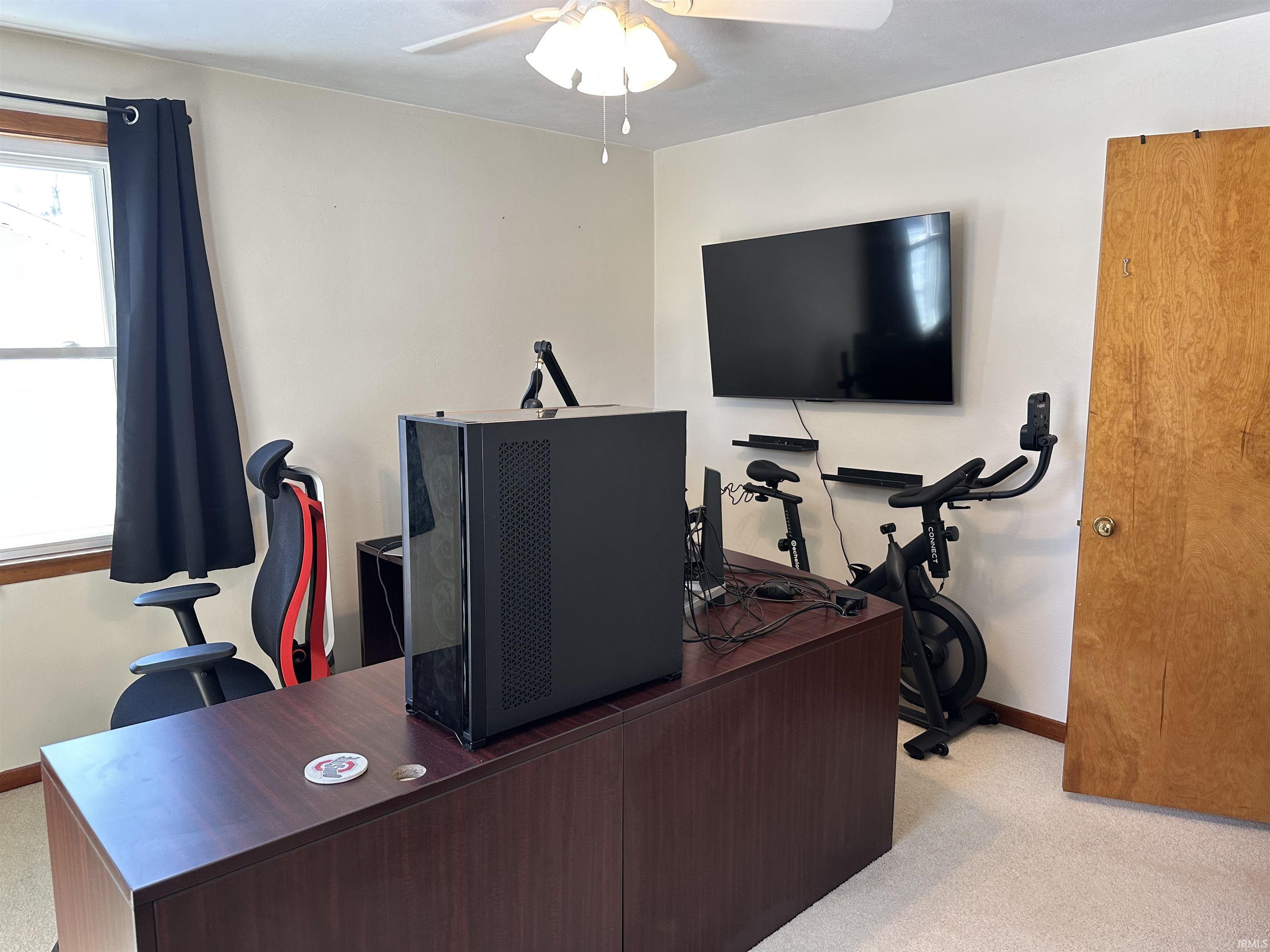 Office featuring light colored carpet and ceiling fan