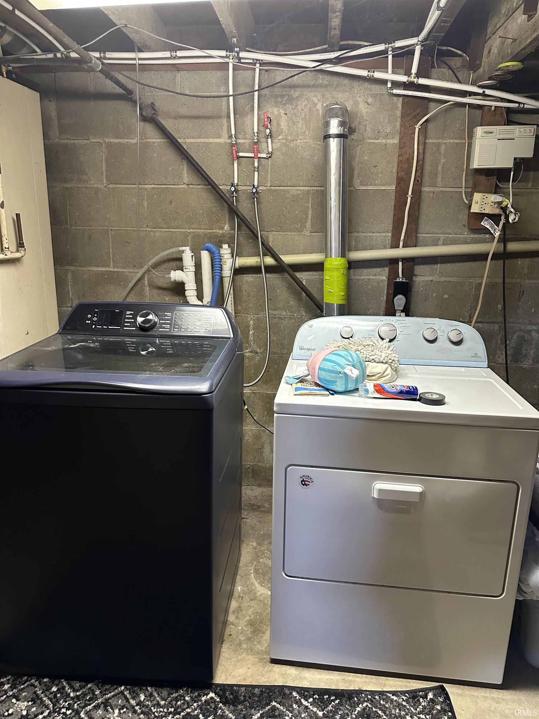 Laundry room featuring concrete floors and washer and clothes dryer