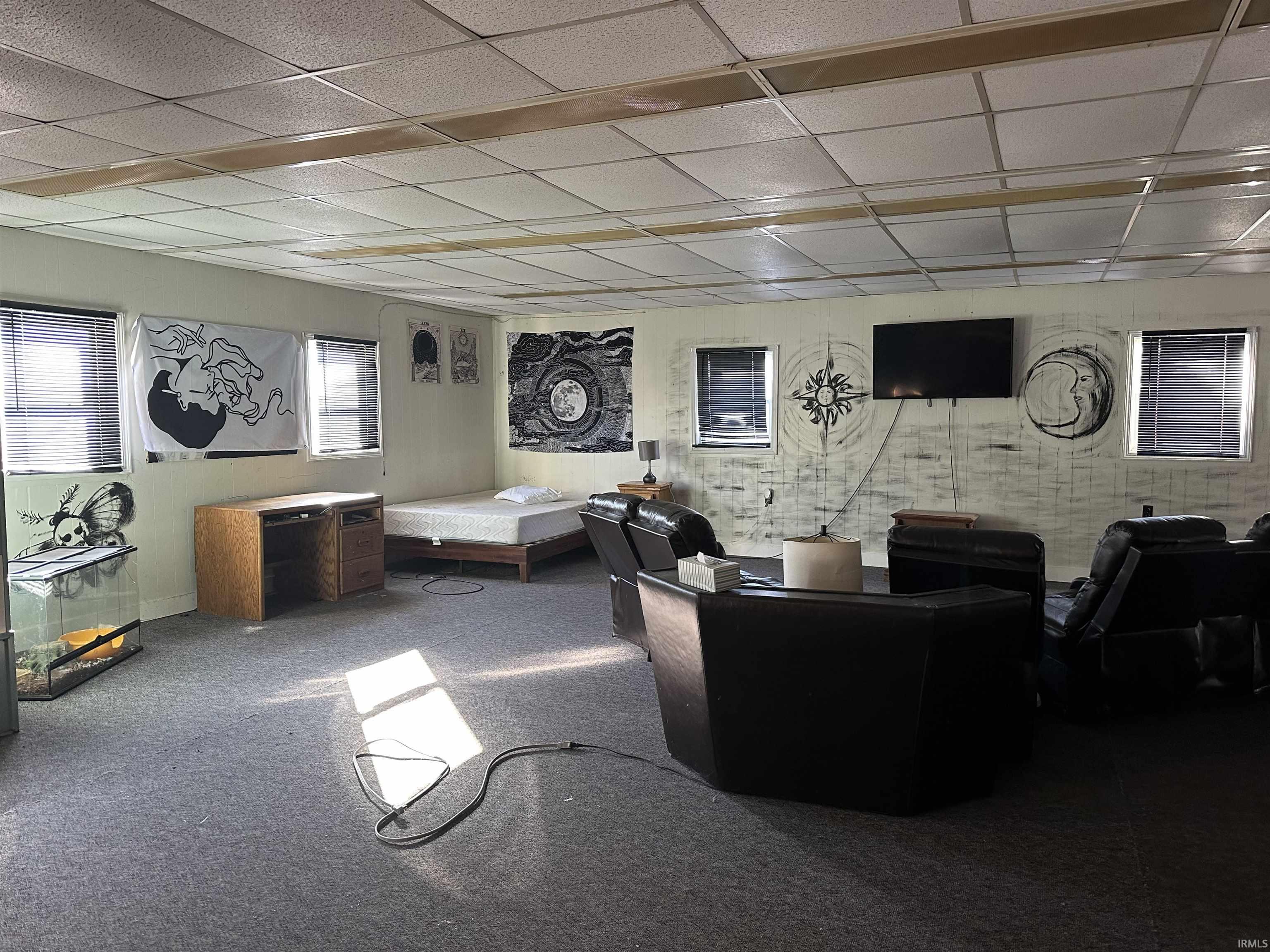 Living room featuring a paneled ceiling and carpet floors