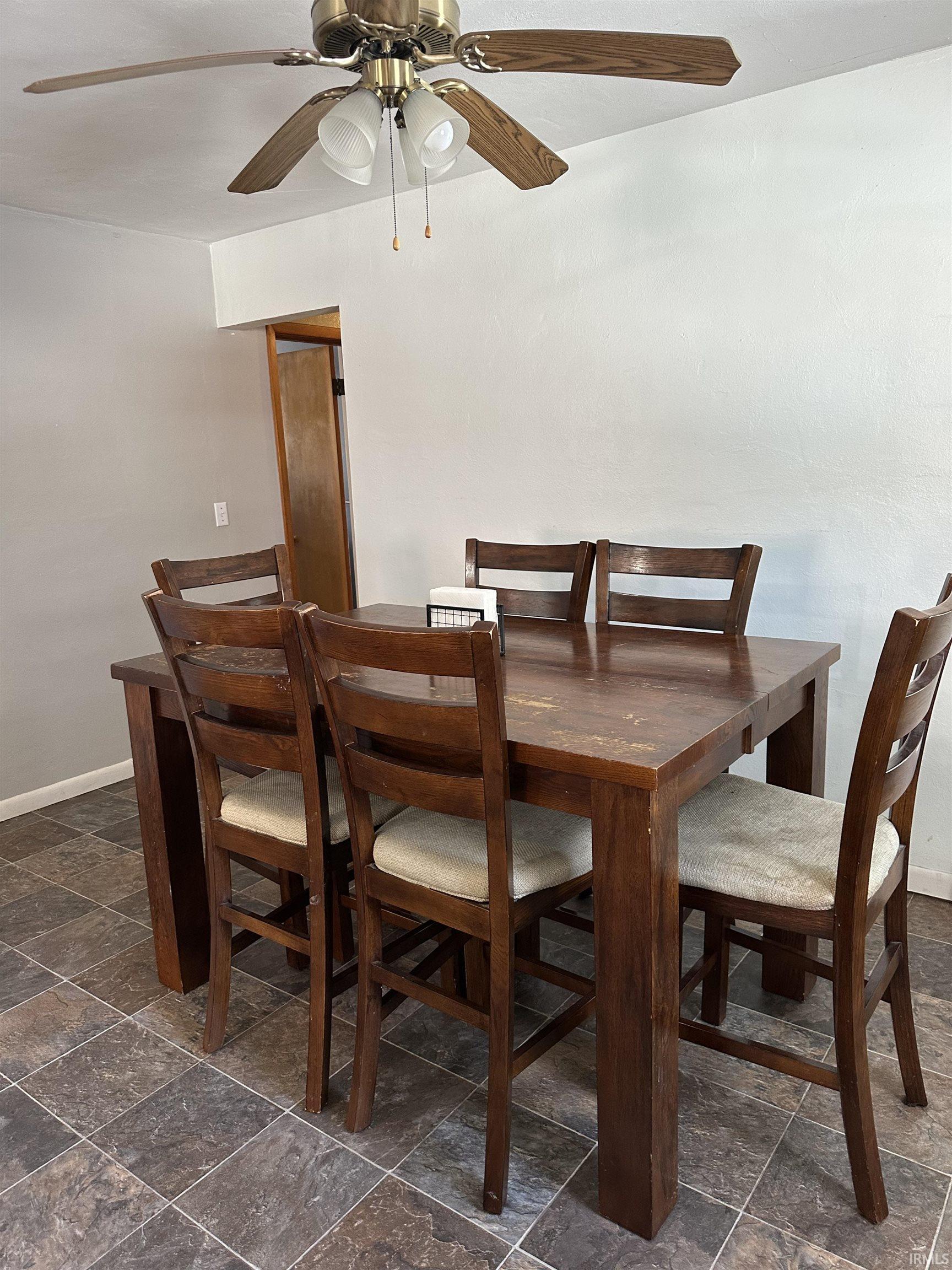 Dining room featuring stone tile floors and a ceiling fan