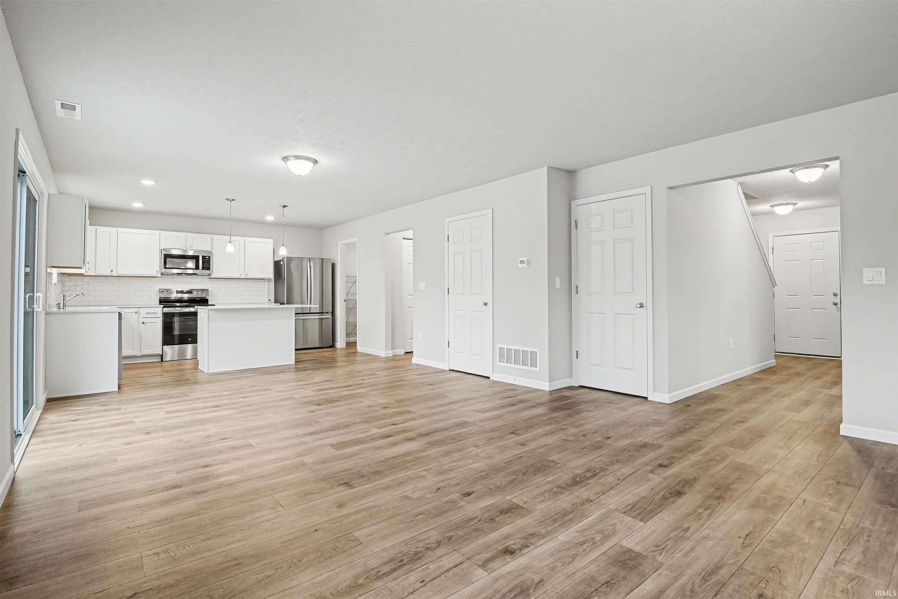 The expansive great room features multiple windows on 2 sides and open sight lines to the nook & kitchen with consistent flooring for cohesive transitions.
